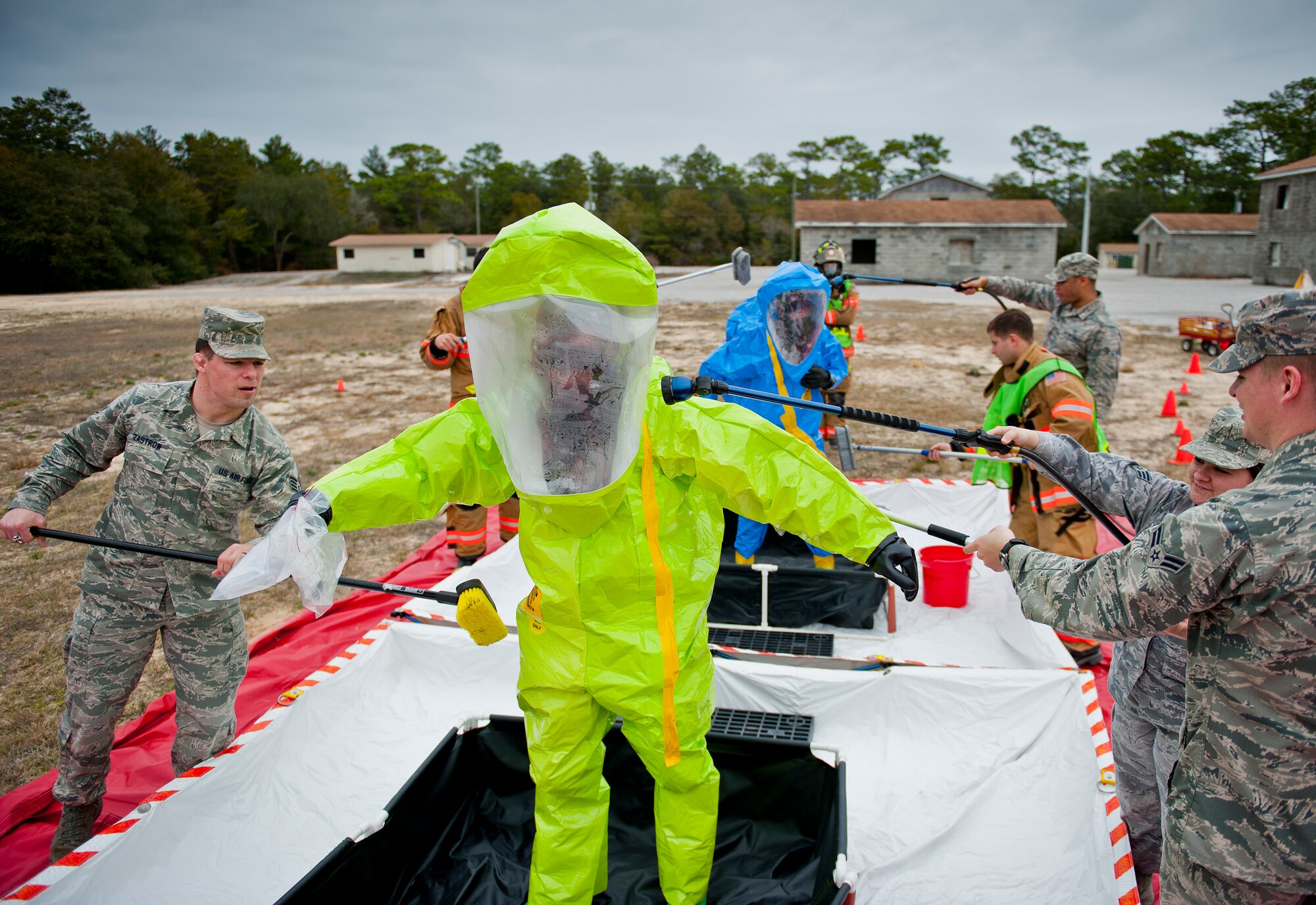 Anyone who enters the chemical tainted “hot zone” must process through the decontamination area where they are washed and scrubbed and safely remove their protective clothing during a 96th Civil Engineer Group training exercise March 2.  The exercise was part of annual training for firefighters, explosive ordnance disposal, emergency management and the 96th Medical Group’s bioenvironmental flight.  The training scenario of a chemical-emitting bomb threat tasked all of the units involved from first response and contaminant detection to bomb deactivation.  (U.S. Air Force photo/Samuel King Jr.)