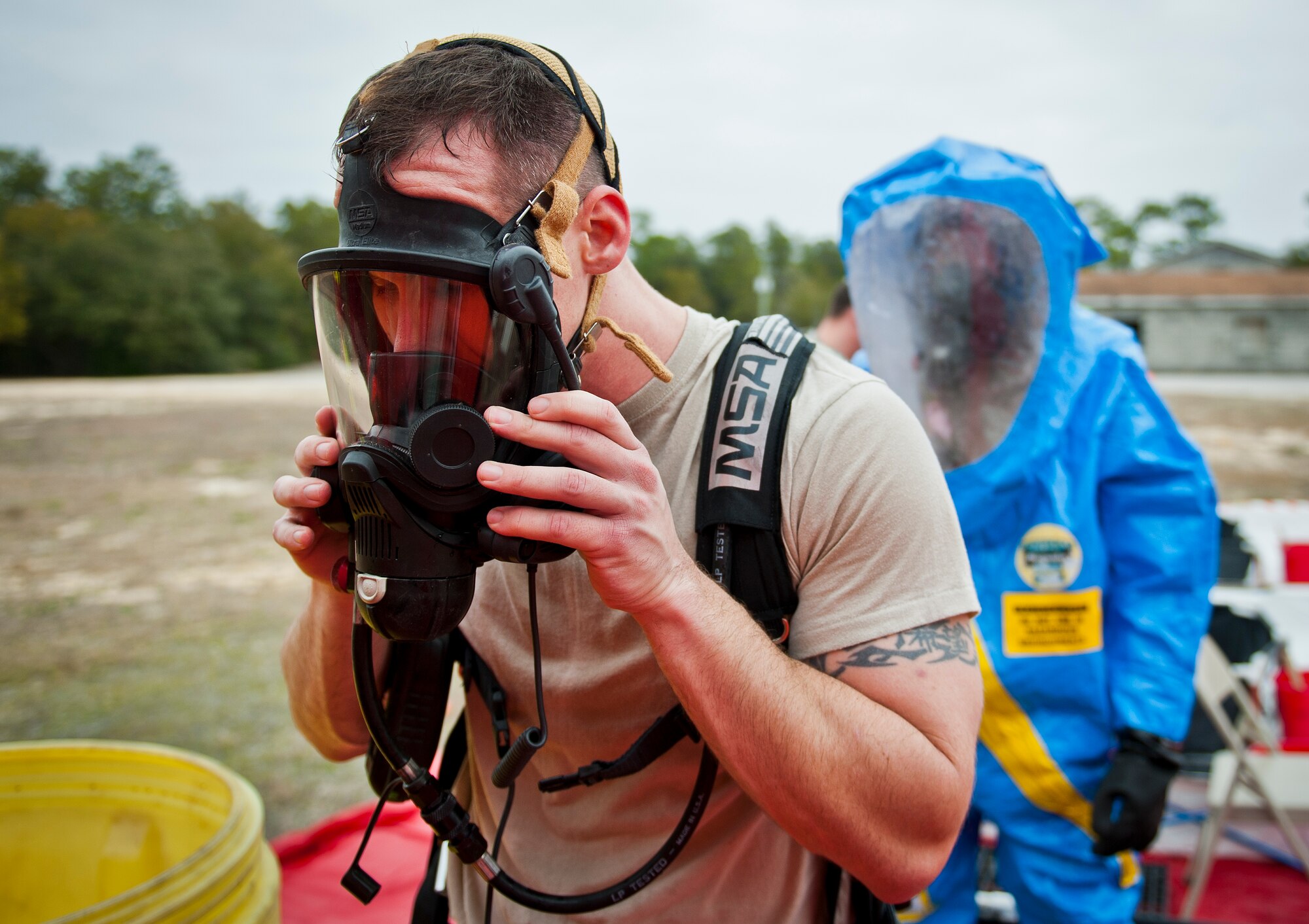 Staff Sgt. Mark Wildrick, of the 96th Emergency Management Flight, begins to remove his respirator during the decontamination process at the 96th Civil Engineer Group training exercise March 2.  The exercise was part of annual training for firefighters, explosive ordnance disposal, emergency management and the 96th Medical Group’s bioenvironmental flight.  The training scenario of a chemical-emitting bomb threat tasked all of the units involved from first response and contaminant detection to bomb deactivation.  (U.S. Air Force photo/Samuel King Jr.)