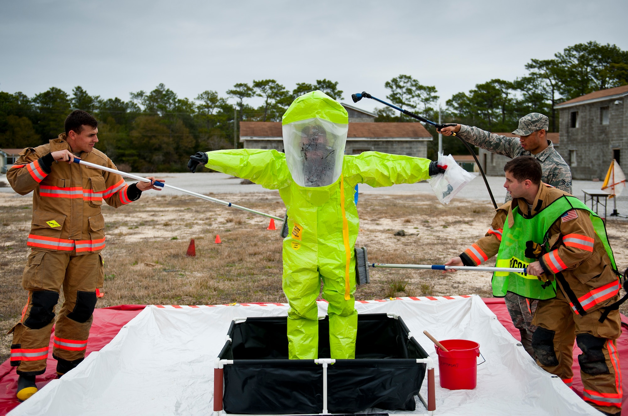 Staff Sgt. Mark Wildrick, of the 96th Emergency Management flight, begins the decontamination process after exiting the “hot zone” during a 96th Civil Engineer Group training exercise March 2.  The exercise was part of annual training for firefighters, explosive ordnance disposal, emergency management and the 96th Medical Group’s bioenvironmental flight.  The training scenario of a chemical-emitting bomb threat tasked all of the units involved from first response and contaminant detection to bomb deactivation.  (U.S. Air Force photo/Samuel King Jr.)