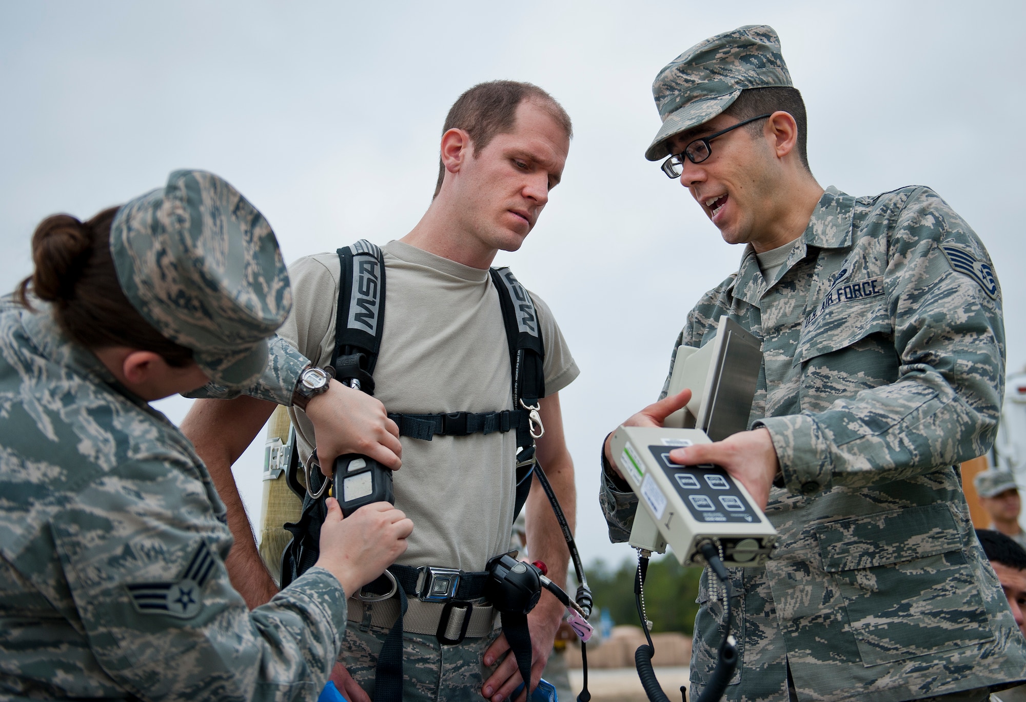 Staff Sgt. Jason Walton briefs Senior Airman Anthony Guciardo, of the 96th bioenvironmental flight, on how to use the ADM 300 device prior to entering a contaminant zone during a 96th Civil Engineer Group training exercise March 2.  The exercise was part of annual training for firefighters, explosive ordnance disposal, emergency management and the bioenvironmental flight.  The training scenario of a chemical-emitting bomb threat tasked all of the units involved from first response and contaminant detection to bomb deactivation.  (U.S. Air Force photo/Samuel King Jr.)