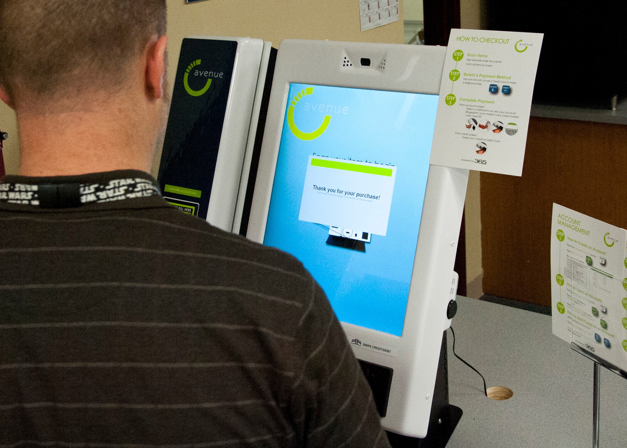 CHEYENNE MOUNTAIN AIR FORCE STATION, Colo. – Steve Hayden, 721st Communications Squadron systems center, checks out at the new Avenue C 24/7 kiosk, March 3, 2015. Replacing the shoppette, the unmanned kiosk is one of the first in AAFES offering healthier food and drink options with a touch of a thumb, credit card or cash. (U.S. Air Force photo by Senior Airman Tiffany Denault)