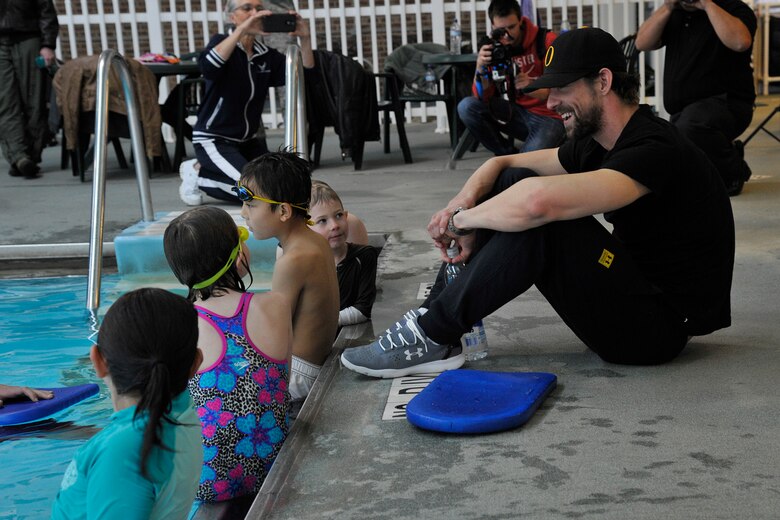 PETERSON AIR FORCE BASE, Colo. – Michael Phelps, 22-time Olympic medalist in swimming, visits with Team Pete im8 swim program participants at the pool March 2, 2015. Phelps came to see the program in action with the swim instructors teaching the im safe module to 14 kids, and taught the kids a few tricks of his own to master their swimming techniques. (U.S. Air Force photo by Robert Lingley)