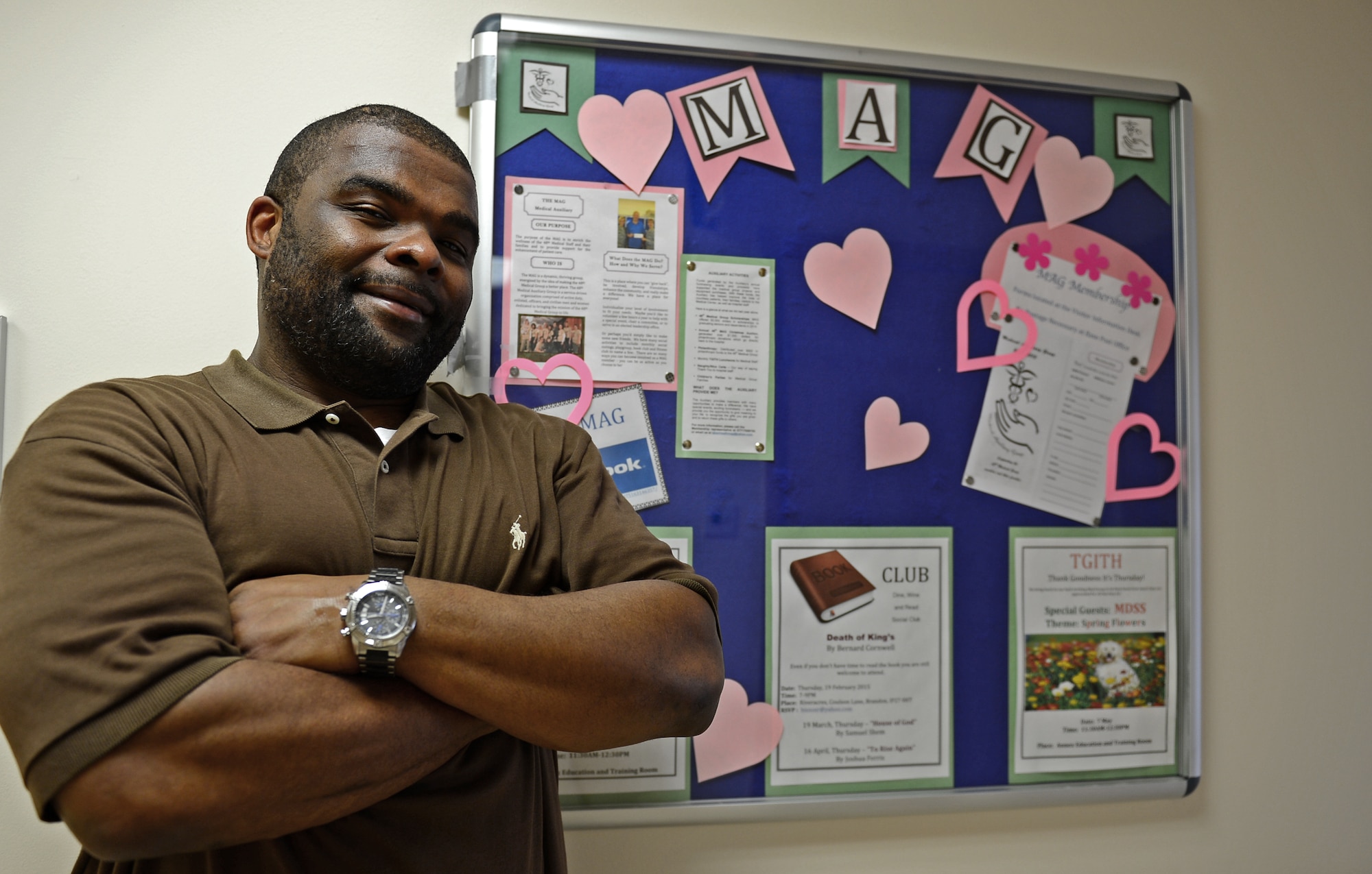 Chris Howard, 48th Medical Support Squadron key spouse, poses in front of the Medical Auxiliary Group board where his themed morale meals, served for the medical squadrons on Thursdays at the Garden Spot cafeteria, are advertised at Royal Air Force Lakenheath, England, Feb. 25, 2015. Howard, husband of Maj. Saunya Bright, 48th MDSS nutritional medicine flight commander, was nominated for a Liberty Spotlight because he embodies the core value of Service Before Self. (U.S. Air Force photo by Airman 1st Class Erin R. Babis/Released)