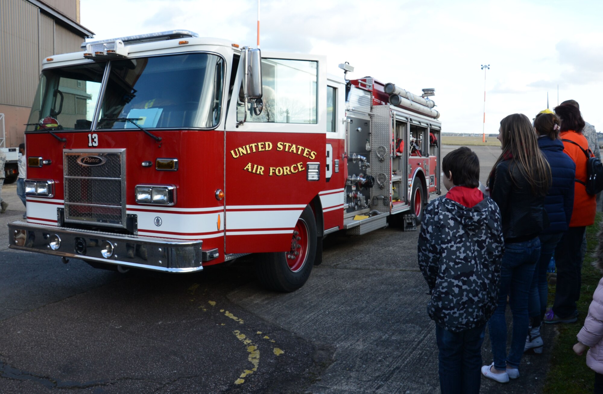 Civilians from the 100th Logistics Readiness Squadron wait in line to sit in a fire truck during a Civilian Appreciation Day tour Feb. 27, 2015, on RAF Mildenhall, England. Airmen and “Sparky” came out to explain how people on base are kept safe by the 100th Civil Engineer Squadron Fire Department in the event of an emergency. (U.S. Air Force photo by Gina Randall/Released)
