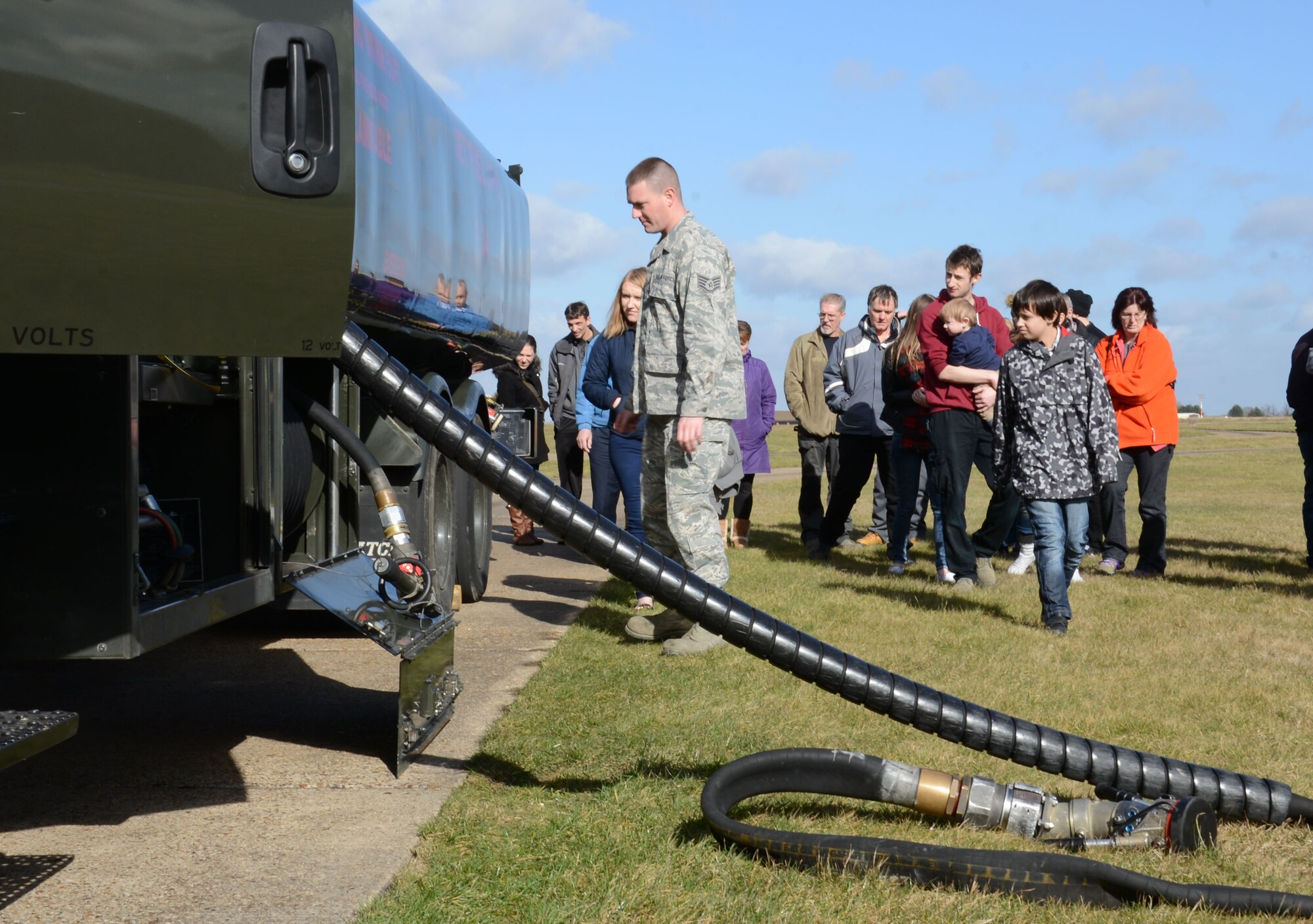 U.S. Air Force Staff Sgt. Jason Stump, front, 100th Logistics Readiness Squadron NCO in charge of Fuels Distribution from St. George, W.Va., explains the functions of a fuel truck to civilians from the 100th LRS during a tour of the fuels flight during a Civilian Appreciation Day tour Feb. 27, 2015, on RAF Mildenhall, England. Stump explained the safety measures his Airmen take to ensure the base population is kept safe while providing fuel for the mission. (U.S. Air Force photo by Gina Randall/Released)