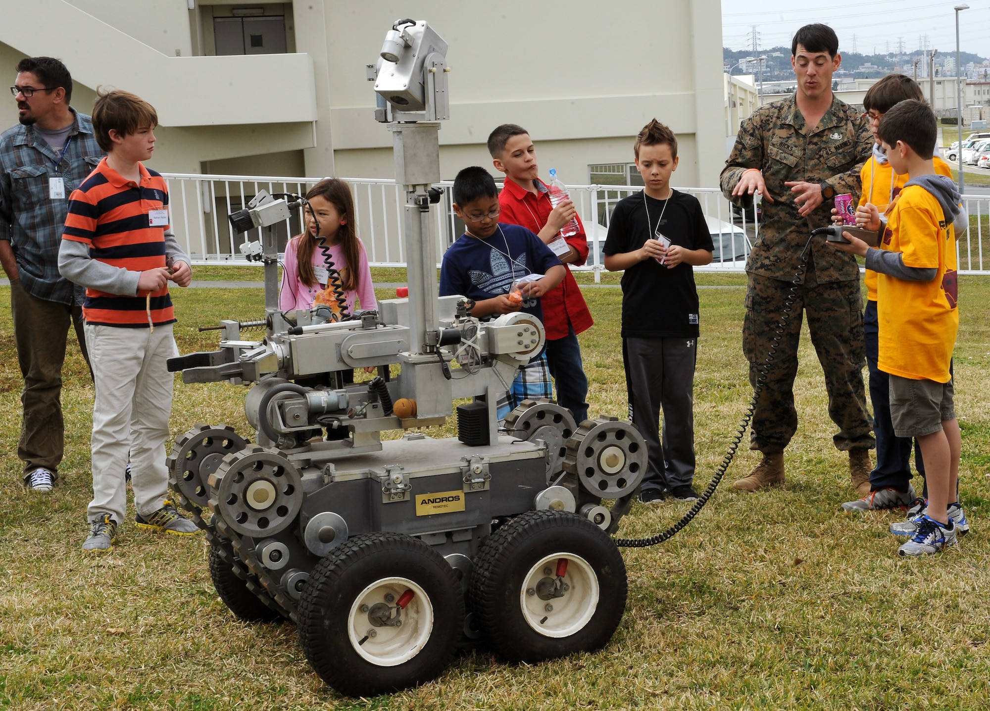 U.S. Marine Corps Sgt. Larry Hicks, Marine Corps Base Explosive Ordnance Disposal technician, lets children from Department of Defense Dependent Schools around the island operate an EOD robot during a robotics competition on U.S. Marine Corps Camp Foster, Japan, Feb. 20, 2015. DoDDS students from around the island participated in the competition, which tested their ability to program robots to perform specific tasks and was intended to spark interest in science, technology, engineering and math. (U.S. Air Force photo by Airman 1st Class Zade C. Vadnais)
