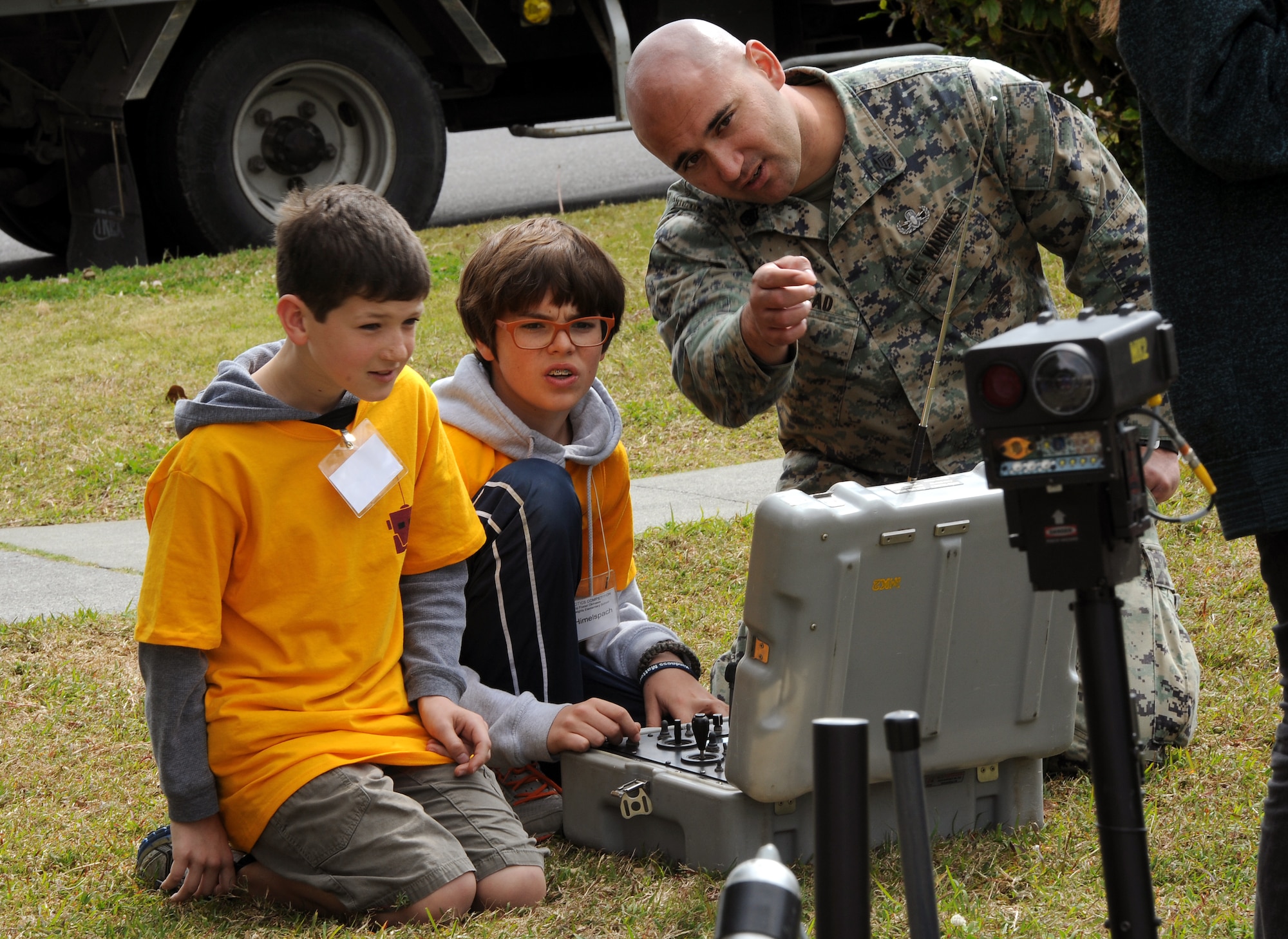 U.S. Marine Corps Staff Sgt. Paul Mead, Marine Corps Base Explosive Ordnance Disposal technician, explains how to operate an EOD robot to Will Himelspach and Ryker Rivinius, both Stearley Heights Elementary School students, during an island-wide robotics competition on U.S. Marine Corps Camp Foster, Japan, Feb. 20, 2015. Two EOD technicians gave a robotics presentation during the competition as a demonstration of a possible career the students could have if they maintain their interests in science, technology, engineering and math. (U.S. Air Force photo by Airman 1st Class Zade C. Vadnais)