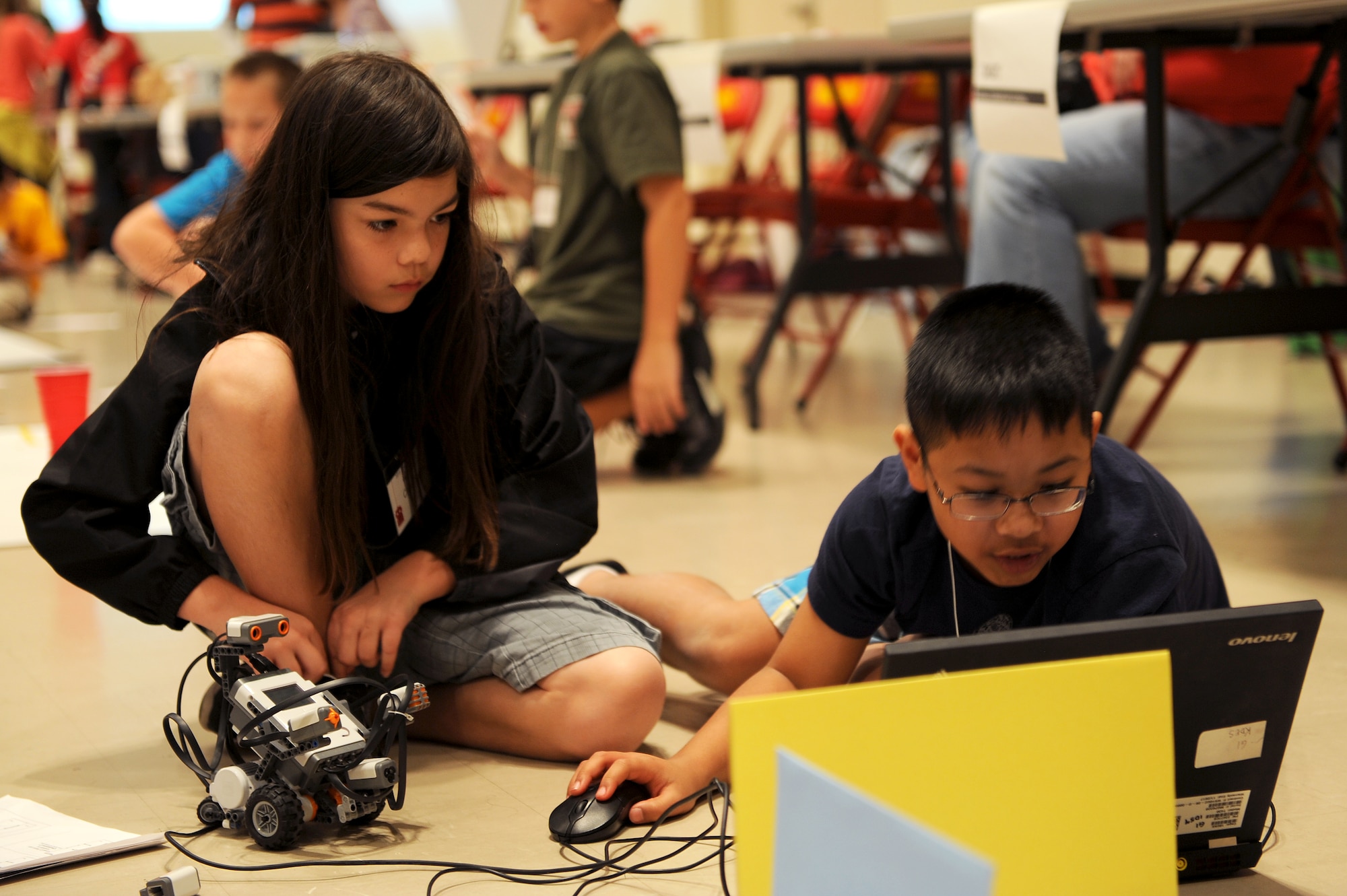 Caitlin Yasuki and Mace Phillips, Kadena Elementary School students, program a robot to navigate an obstacle course during an island-wide robotics competition on U.S. Marine Corps Camp Foster, Japan, Feb. 20, 2015. Students from Department of Defense dependent elementary, middle and high schools around the island participated in the day-long competition which tested their ability to program a robot to perform various tasks. (U.S. Air Force photo by Airman 1st Class Zade C. Vadnais)
