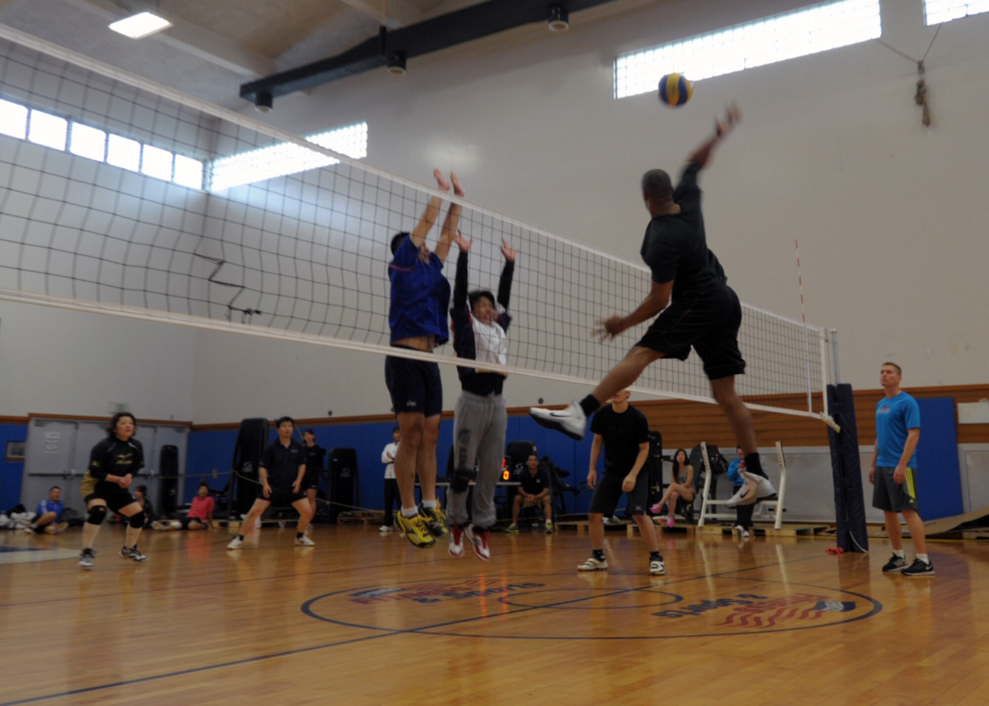 Jeremy Turner leaps for a spike against a team from Okinawa City during an invitational volleyball tournament Feb. 28, 2015, at Kadena Air Base, Japan. Members of the Company Grade Officer Council and Airmen Committed to Excellence invited two Japanese teams to the base for a day of sportsmanship and camaraderie. (U.S. Air Force photo by Tim Flack)