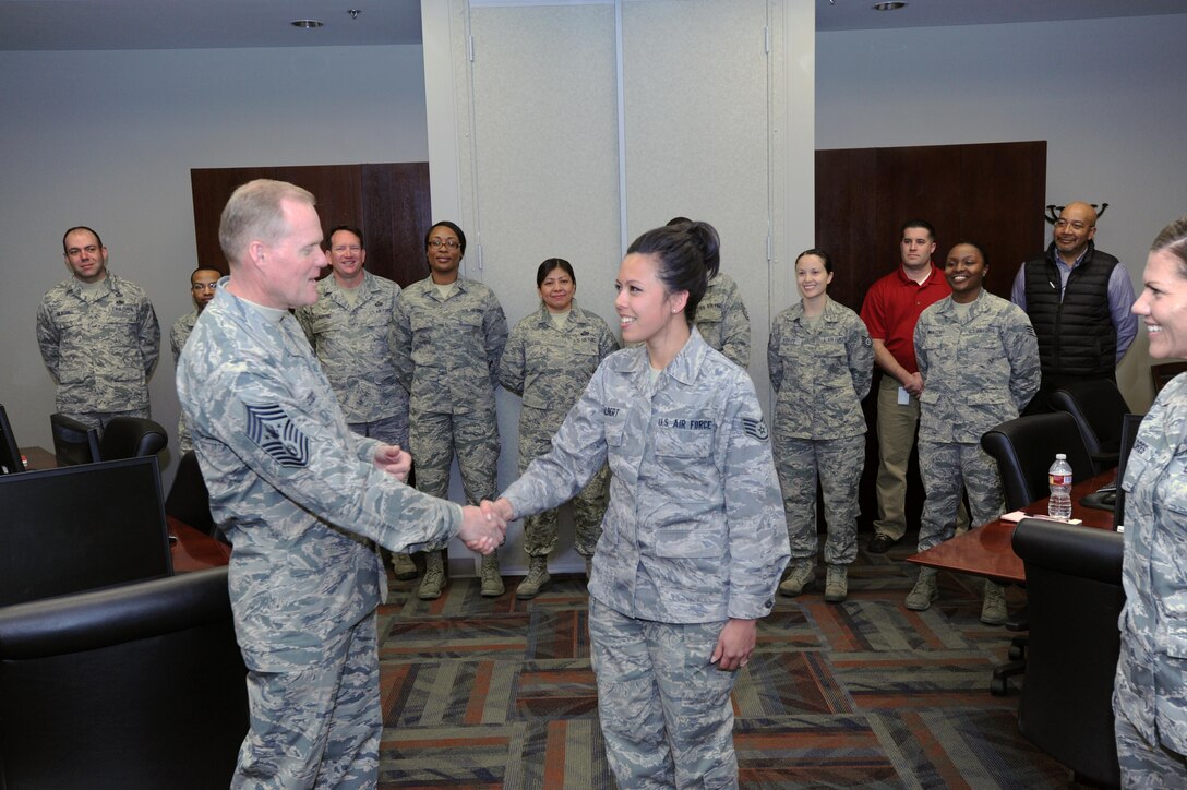Chief Master Sgt. of the Air Force James A. Cody presents a coin to Staff Sgt. Ashley Jalbert, Air Reserve Personnel Center board operations technician, during his visit to ARPC March 5, 2015, on Buckley Air Force Base, Colo. Cody’s visit focused on the future of the Air Force as he met with Airmen and discussed his role and priorities. (U.S. Air Force photo/Tech. Sgt. Rob Hazelett)