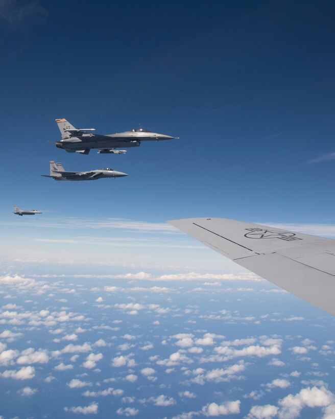 Two F-16 Fighting Falcons from the 162nd Fighter Wing, Arizona Air National Guard, and one F-15 Strike Eagle from the 142nd Fighter Wing, Oregon Air National Guard, fly in formation off the left wing of a KC-135R Stratotanker from the 96th Air Refueling Squadron, during the Hawaii Air National Guard’s large-scale fighter exercise Sentry Aloha over Hawaii, March. 5, 2015.  Additionally the F-22 Raptor, A-10 Warthog, C-130 Hercules and U.S. Naval F/A-18 Hornet will participate in Sentry Aloha. (U.S. Air Force photo by Tech. Sgt. Aaron Oelrich/Released)