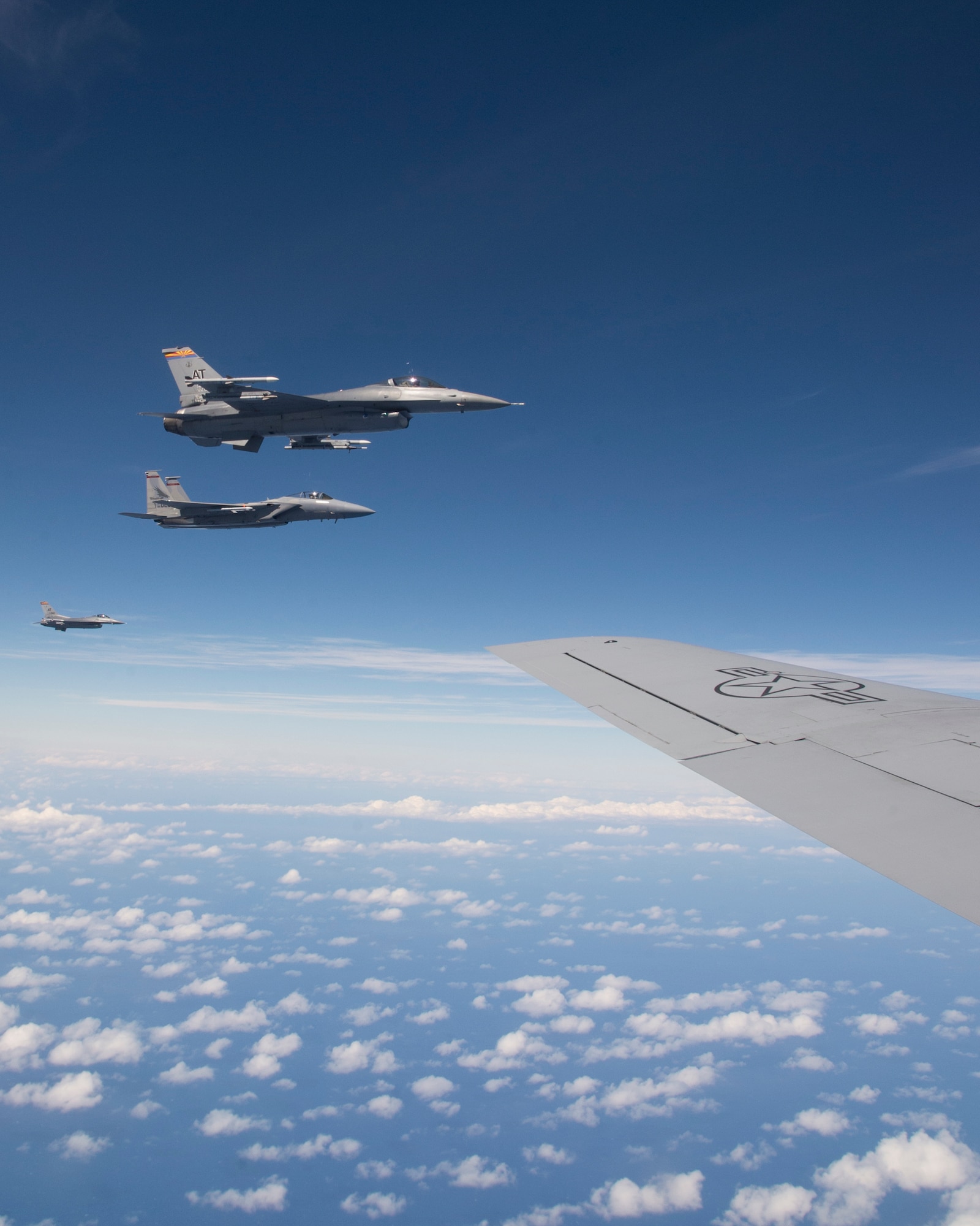 Two F-16 Fighting Falcons from the 162nd Fighter Wing, Arizona Air National Guard, and one F-15 Strike Eagle from the 142nd Fighter Wing, Oregon Air National Guard, fly in formation off the left wing of a KC-135R Stratotanker from the 96th Air Refueling Squadron, during the Hawaii Air National Guard’s large-scale fighter exercise Sentry Aloha over Hawaii, March. 5, 2015.  Additionally the F-22 Raptor, A-10 Warthog, C-130 Hercules and U.S. Naval F/A-18 Hornet will participate in Sentry Aloha. (U.S. Air Force photo by Tech. Sgt. Aaron Oelrich/Released)