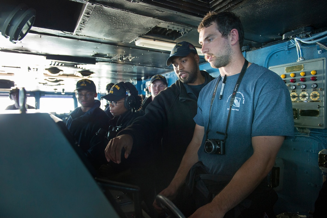 Andrew Luck, Indianapolis Colts quarterback, right, is at the helm, steering the aircraft carrier USS Carl Vinson in the Arabian Gulf, March 5, 2015.