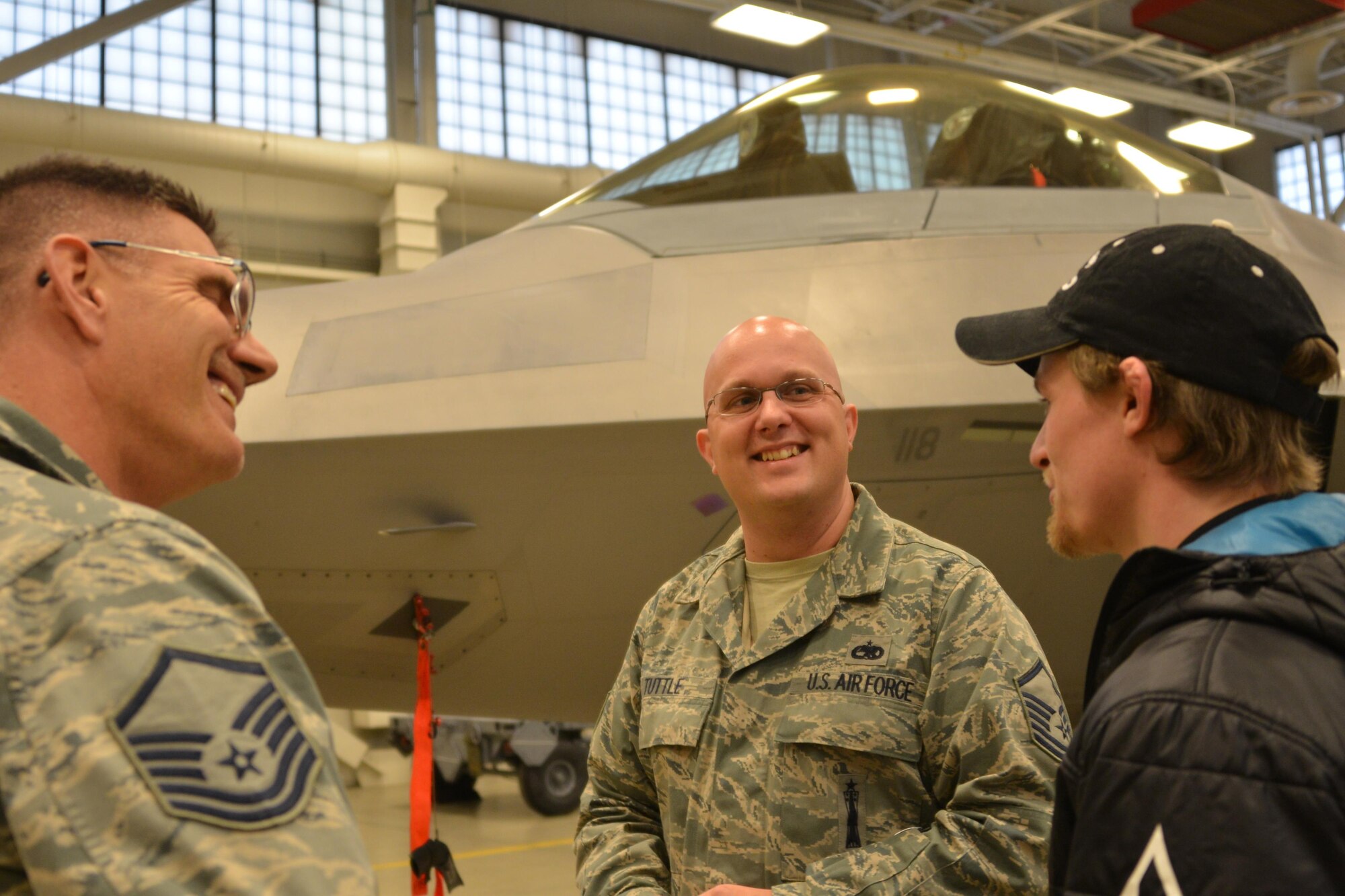 Master Sgts Daniel Fried and Timothy Tuttle, 477th Aircraft Maintenance Squadron, F-22 weapons visit with Dallas Seavey, two-time Iditarod champion, during his visit with Airmen from the 477th Fighter Group. (U.S. Air Force/Capt. Megan Liemburg-Archer)