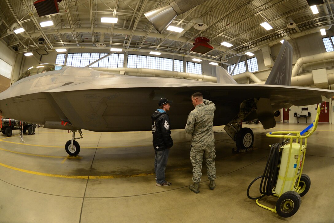 Two-time Iditarod champion, Dallas Seavey gets a tour of the F-22 from Tech. Sgt. Andrew Eichorst, 477th Aircraft Maintenance Squadron, F-22 crew chief. This year marks the 43rd running of the Iditarod and the first year of the Air Force Reserve’s sponsorship. (U.S. Air Force/Tech. Sgt. Dana Rosso)

