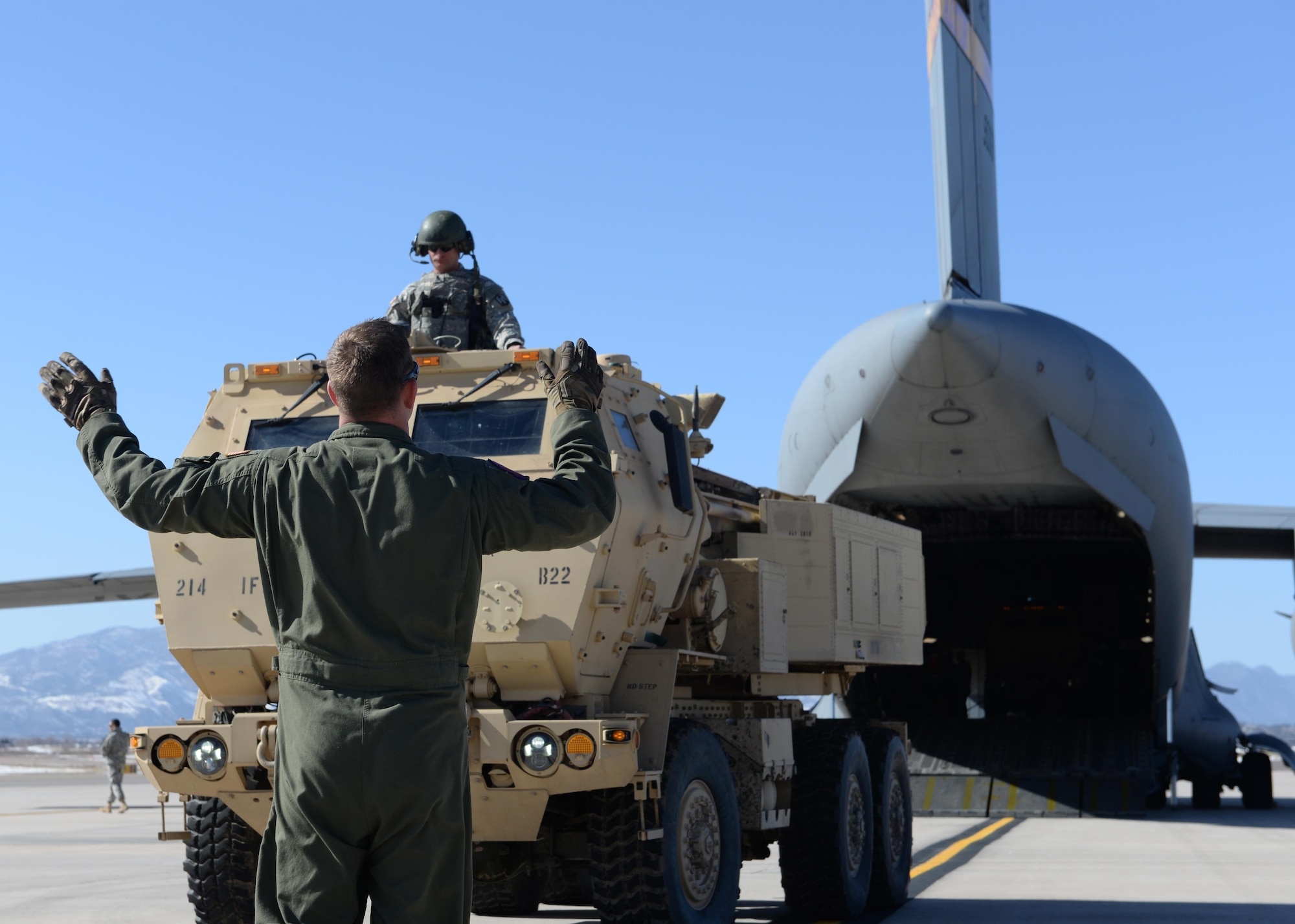 Air Force Staff Sgt. Jeffery Purvis directs an Army M142 High Mobility Artillery Rocket System onto an C-17 Globemaster III March 6, 2015, at Peterson Air Force Base, Colo. The training helped Airmen and Soldiers stay proficient in transporting, setting up and firing a HIMARS. The Soldiers were from the 1st Battalion, 14 Field Artillery Regiment, 214th Fires Brigade and Airmen were from the 58th Airlift Squadron and the 97th Logistics Readiness Squadron. (U.S. Air Force photo/Airman 1st Class Nathan Clark)
