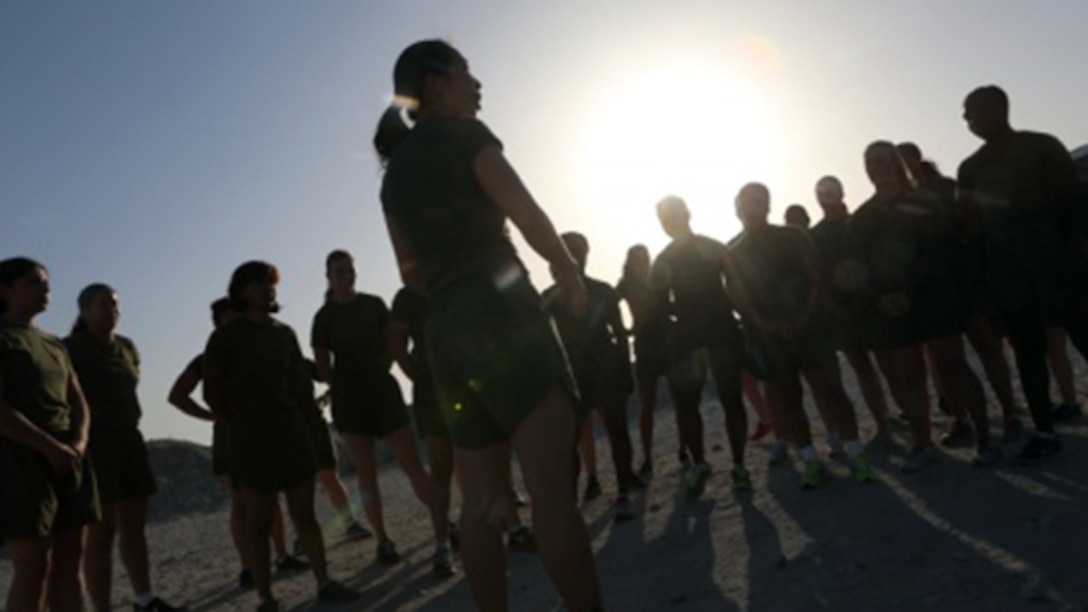 Women Marines attached to Special Purpose Marine Air Ground Task Force – Crisis Response – Central Command, gather around Staff Sgt. Becky S. Lam, a maintenance chief with Marine Air Control Squadron 1, after a motivational run during the Women Marine Symposium, March 2, 2015, in the Central Command area of operations. The symposium was organized to inform the participants about upcoming changes for women Marines, to share the rich history of women in the Corps and to encourage leadership and esprit de corps. 