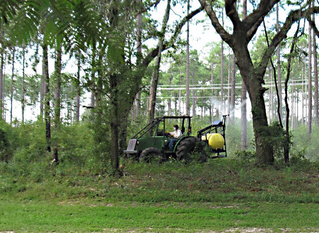 Mark Atwater, contractor, Marine Corps Logistics Base Albany, sprays herbicides to control undesirable vegetation aboard the base, recently.      