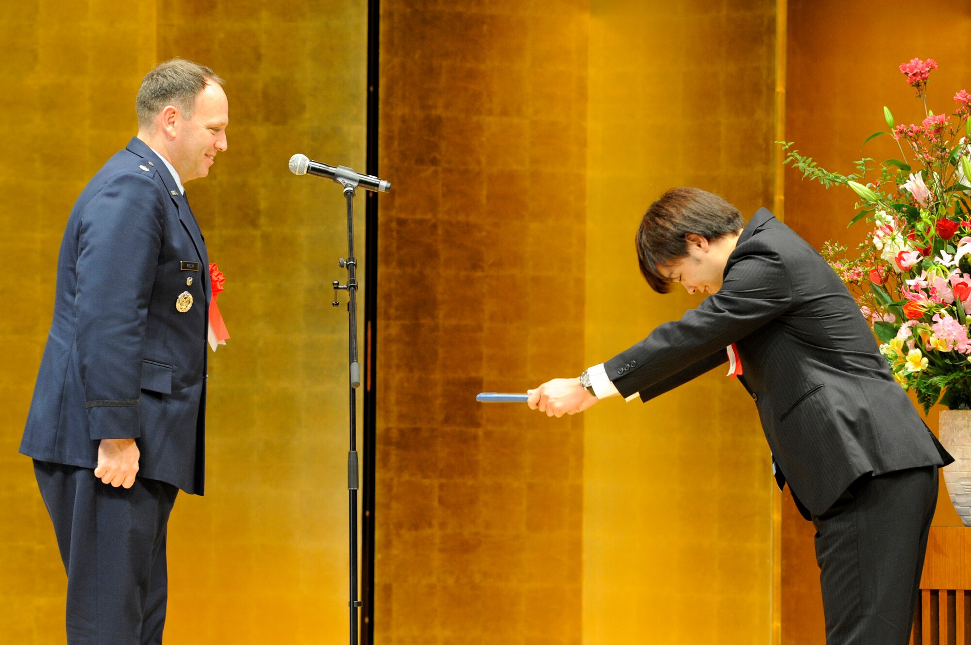 U.S. Air Force Lt. Col. Kieran Keelty, 18th Mission Support Group deputy commander, presents Keigo Irei with the Best Intern award at the Rotary Plaza during the Kadena Language Institute class of 2015’s graduation in Kadena Town, Japan, March 6, 2015. According to the Kadena Marina, Irei made significant improvements to his English skills, worked energetically and had consistent professionalism during his internship with them. (U.S. Air Force photo by Staff Sgt. Marcus Morris)