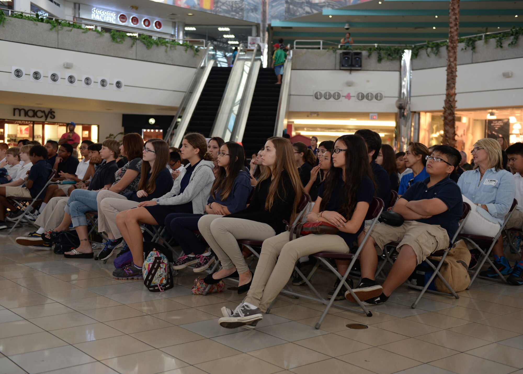 Department of Defense Education Activity school band children sit and listen to the Air Force Band of the Pacific’s Papana, from Joint Base Pearl Harbor Hickam, HI, play jazz music during a performance Mar. 10, 2015, at the Micronesia Mall in Dededo, Guam. The Air Force Band of the Pacific’s Papana supports the U.S. Pacific command strategies of partnership, readiness and presence by conducting protocol, community and nation-building missions throughout the pacific. (U.S. Air Force photo by Senior Airman Cierra Presentado/Released)