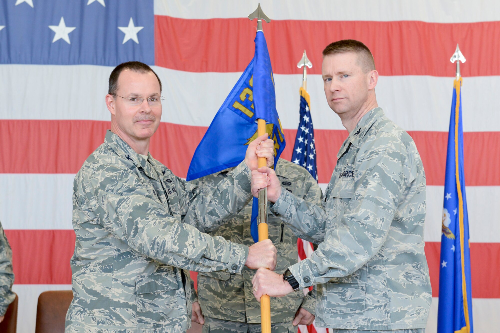 Col. Kevin Heer (left), Commander, 132d Wing (132WG), Des Moines, Iowa, passes the 132d Intelligence Surveillance Reconnaissance Group (ISRG) guidon to Col. Mark Chidley (right), 132WG ISRG Commander, during the 132WG ISRG Activation Ceremony held in the 132WG Fire House on Saturday, March 7, 2015.  This ceremony formally recognizes the official activation of the 132WG ISRG.  (U.S. Air National Guard photo by Staff Sgt. Linda K. Burger/Released)