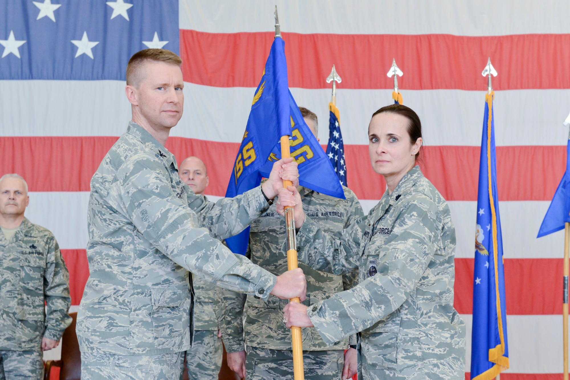 Col. Mark Chidley (left), 132d Wing (132WG), Des Moines, Iowa  Intelligence Surveillance Reconnaissance Group (ISRG) Commander, passes the 132d Intelligence Support Squadron (132 ISS) guidon to Lt. Col. Leslie Zyzda-Martin (right), 132 ISS Commander, during the 132WG ISRG Activation Ceremony held in the 132WG Fire House on Saturday, March 7, 2015.  This ceremony formally recognizes the official activation of the 132WG ISRG.  (U.S. Air National Guard photo by Staff Sgt. Linda K. Burger/Released)