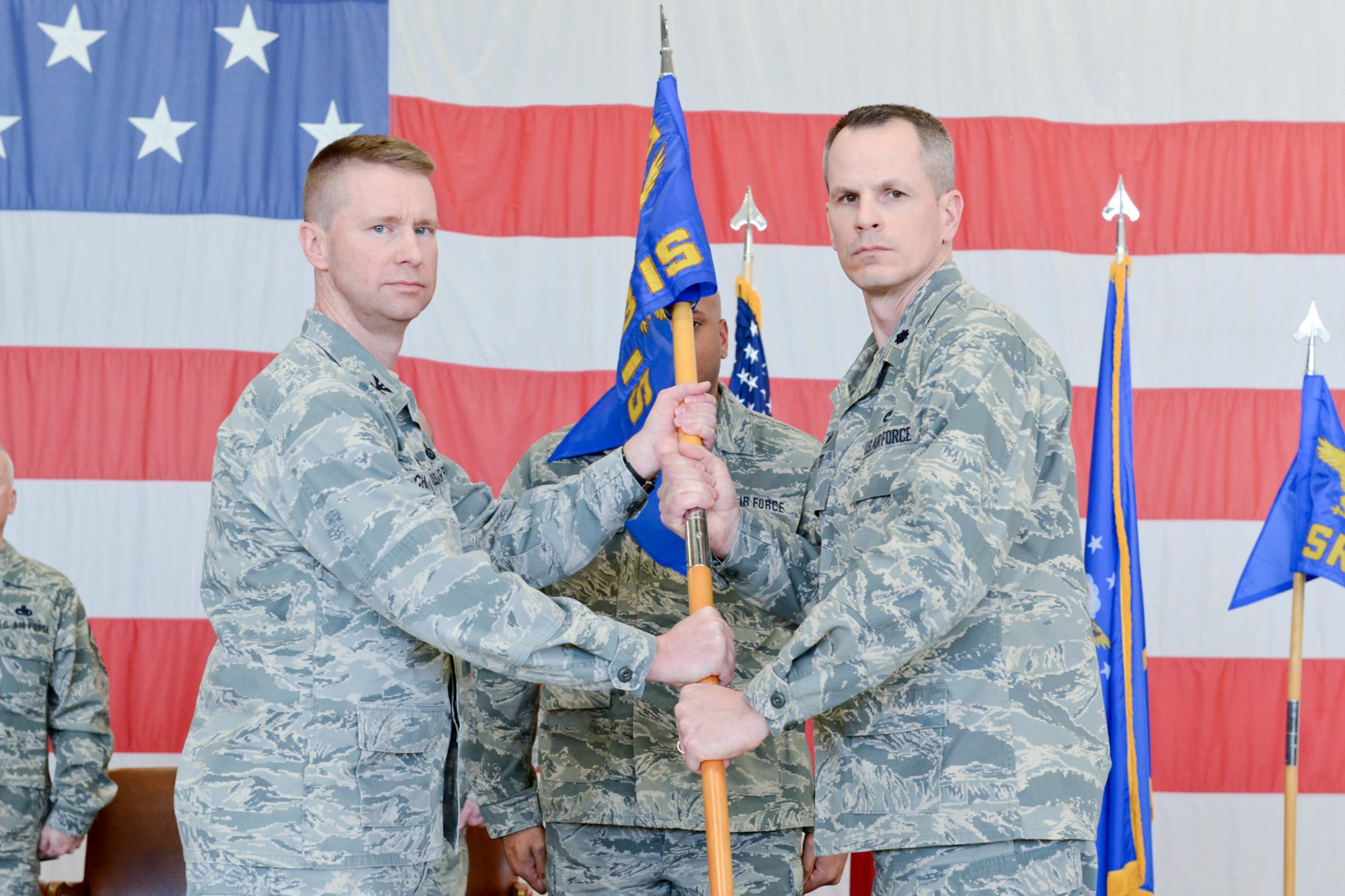 Col. Mark Chidley (left), 132d Wing (132WG), Des Moines, Iowa  Intelligence Surveillance Reconnaissance Group (ISRG) Commander, passes the 233d Intelligence Squadron (233 IS) guidon to Lt. Col. Trenton Twedt (right), 233 IS Commander, during the 132WG ISRG Activation Ceremony held in the 132WG Fire House on Saturday, March 7, 2015.  This ceremony formally recognizes the official activation of the 132WG ISRG.  (U.S. Air National Guard photo by Staff Sgt. Linda K. Burger/Released)