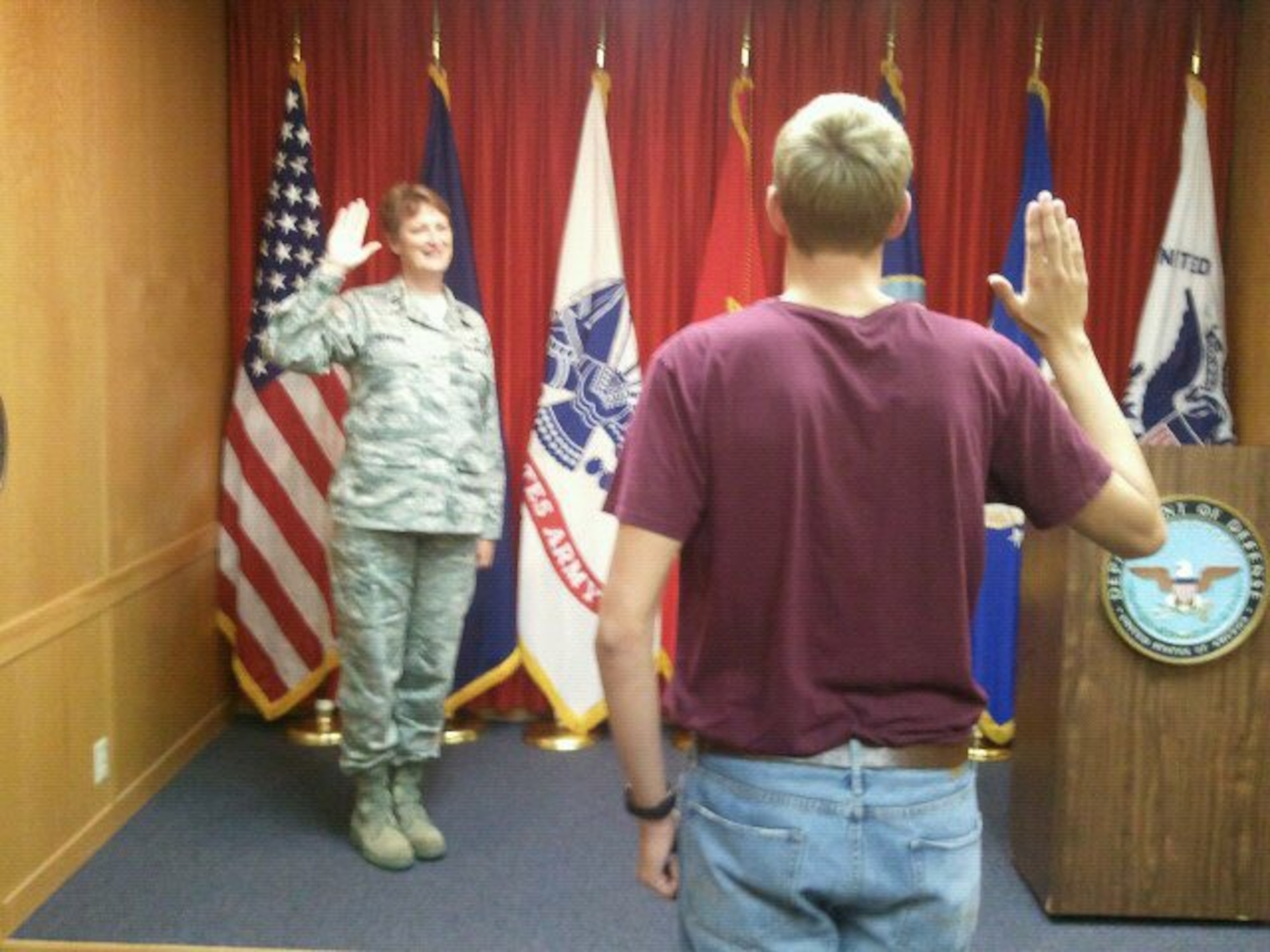 Capt. Dawn Clauson, 99th Medical Operations Squadron pediatric clinic nurse manager, administers the oath of enlistment to her son, David Clauson, in 2011. Dawn commissioned in 2006 and helped inspire David to enlist as soon as he was of legal age. (Courtesy photo)