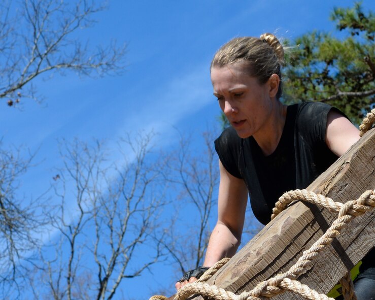 Kelli Woodson uses a rope to climb over an A-frame during a mud run on Barksdale Air Force Base, La., March 7, 2015. Woodson was the female first place winner of the competitive wave of the mud run with a time of 1:03:26. She paced 16:16 per mile for the four-mile course. (U.S. Air Force photo/Senior Airman Benjamin Raughton)
