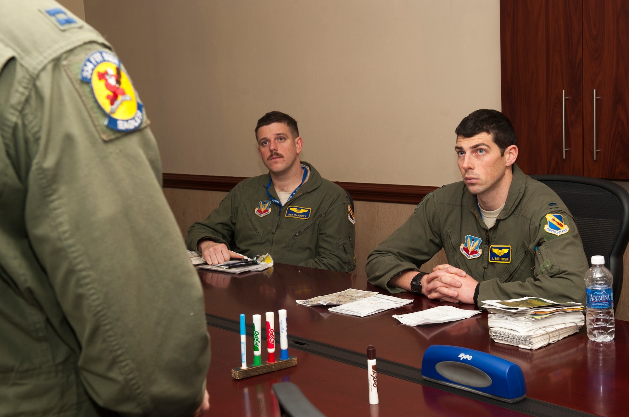 From left, 1st Lts. Ben Hammett, 334th FS student weapons system officer, and A.J. Brothersen, 334th Fighter Squadron student pilot listen to an instructor, during a training flight debrief at Seymour Johnson Air Force Base, North Carolina, Dec. 10, 2014. Students study basic fighter maneuvers, where they will learn air combat maneuvers and air-to-air tactical intercepts. (U.S. Air Force photo/Airman Shawna L. Keyes) 