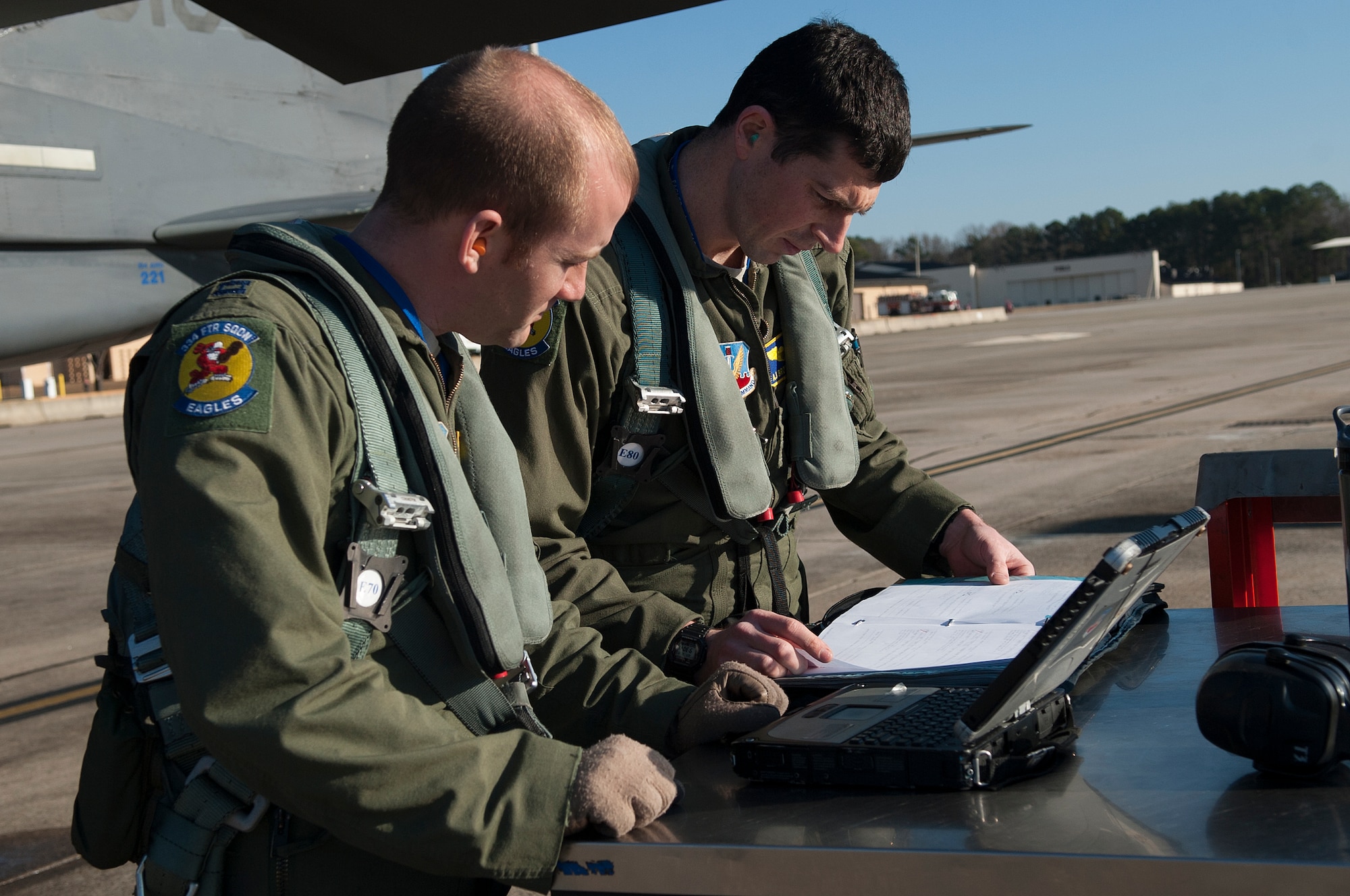 From left, Capt. Ryan Leavitt, 334th Fighter Squadron weapons systems officer instructor, and 1st Lt. AJ Brothersen, 334th FS student pilot, review maintenance forms prior to a training flight, Dec. 10, 2014, at Seymour Johnson Air Force Base, North Carolina. Instructors are paired with students during training flights to receive hands-on training in the F-15E Strike Eagle. (U.S. Air Force photo/Airman Shawna L. Keyes)   