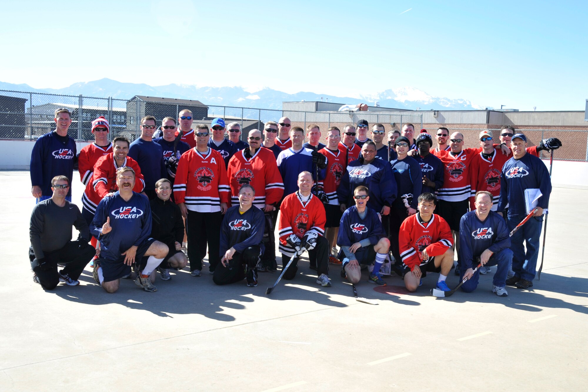 PETERSON AIR FORCE BASE, Colo. – Members of Team USA and Team Canada pose for a photo after the second annual Team USA vs. Team Canada ball hockey tournament at the base hockey rink, Mar. 6. The two teams faced off in a “best-of-three” style tournament, in which Team Canada retained their title of champions.