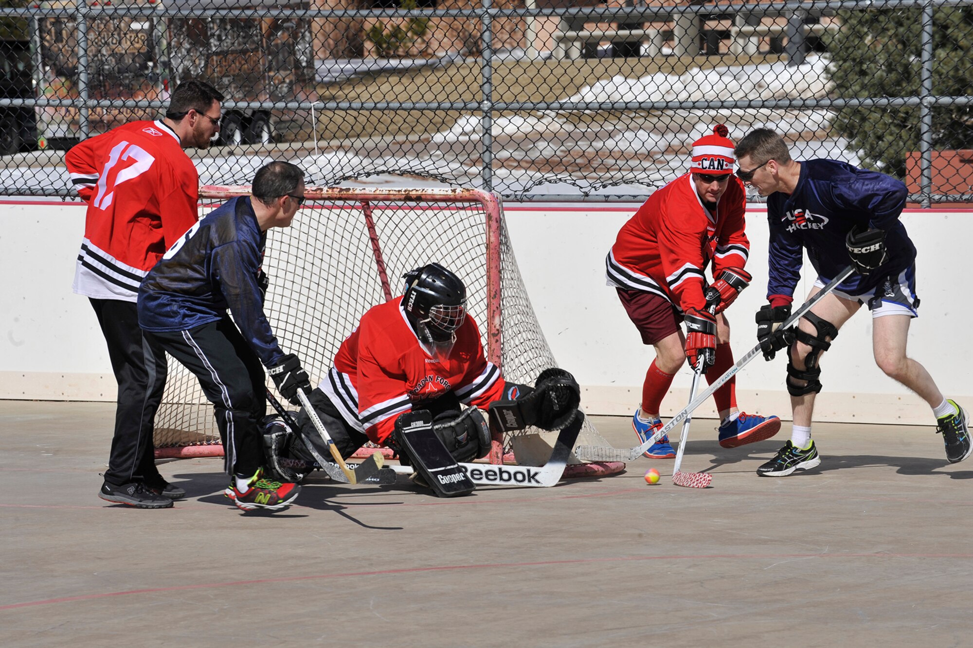 PETERSON AIR FORCE BASE, Colo. – Members of Team USA scramble against the defenders of Team Canada for a shot on goal during the second annual Team USA vs. Team Canada ball hockey tournament at the base hockey rink, Mar. 6. The two teams faced off in a “best-of-three” style tournament, in which Team Canada retained their title of champions.