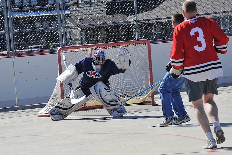 PETERSON AIR FORCE BASE, Colo. – Lt. Col. Miguel Rosales, Team USA, snaps the ball from the air after a shot on goal during the second annual Team USA vs. Team Canada ball hockey tournament at the base hockey rink, Mar. 6. The two teams faced off in a “best-of-three” style tournament, in which Team Canada retained their title of champions.