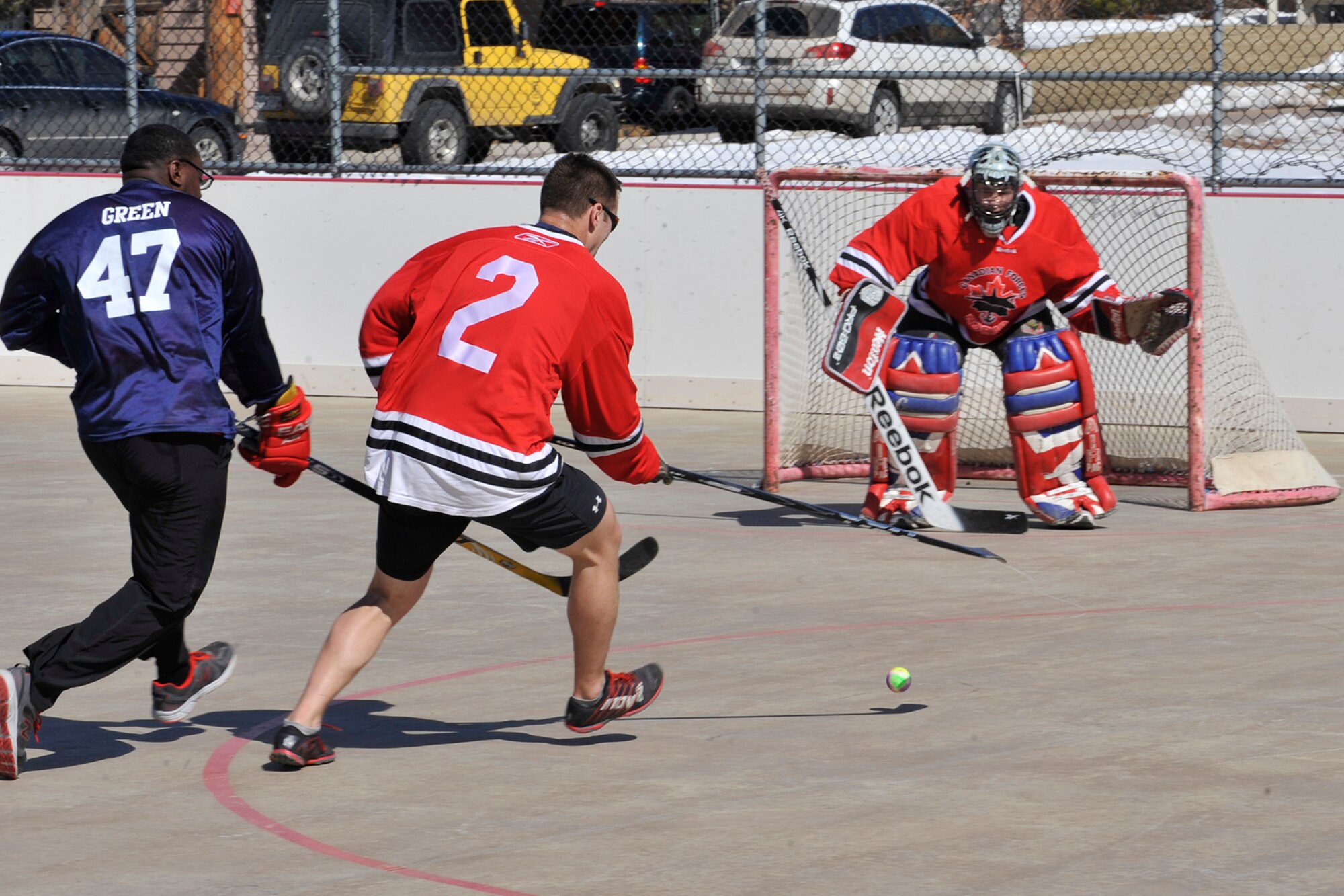 PETERSON AIR FORCE BASE, Colo. – During an attempt for a shot on goal, Senior Airman Jojuan Green, Team USA, is cut off by Master Cpl. Jamie Fitzpatrick,  Team Canada, during the second annual Team USA vs. Team Canada ball hockey tournament at the base hockey rink, Mar. 6. The two teams faced off in a “best-of-three” style tournament, in which Team Canada retained their title of champions.