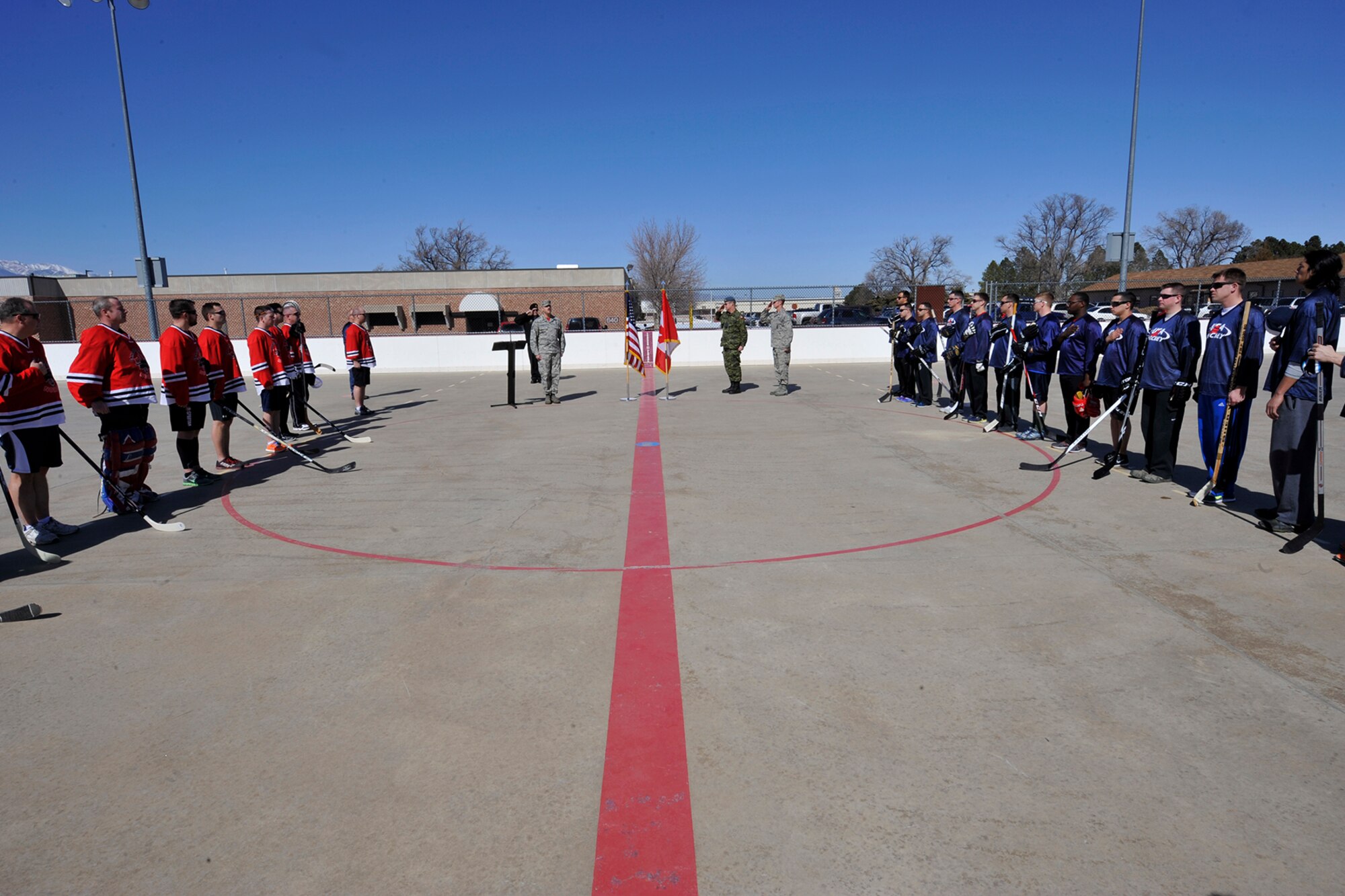 PETERSON AIR FORCE BASE, Colo. -- Teams USA and Canada stand for the playing of both countries’ national anthems during the opening ceremonies of the second annual USA vs. Canada ball hockey tournament at the base hockey rink, Mar. 6. The two teams faced off in a “best-of-three” style tournament, in which Team Canada retained their title of champions.
