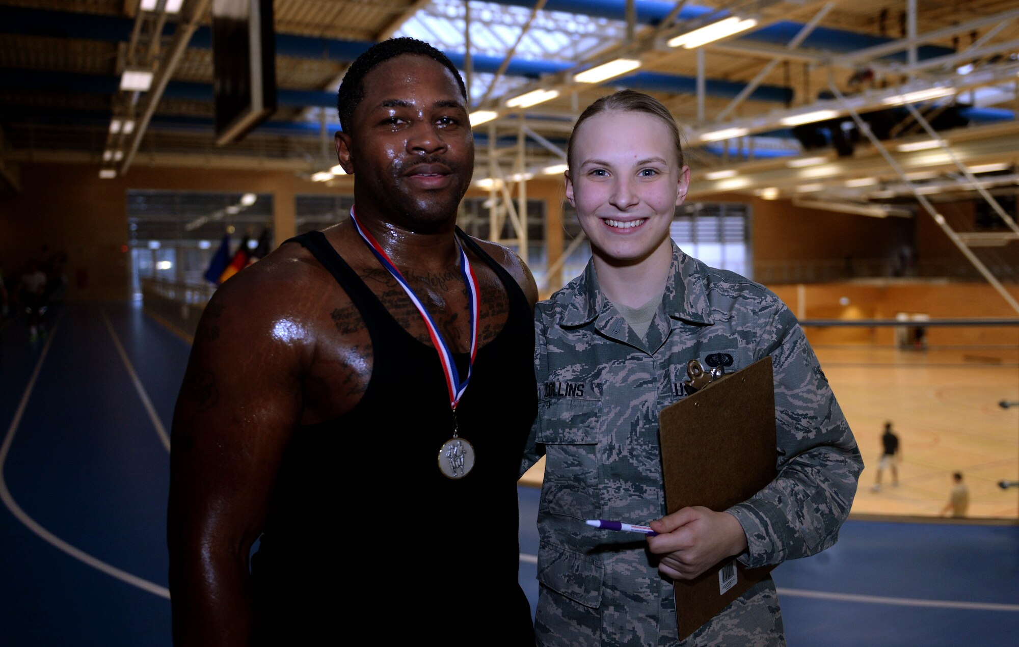U.S. Air Force Staff Sgt. Christopher Dennis, 52nd Maintenance Group maintenance management analysis NCO in charge, left, and U.S. Air Force Airman Kimberly Collins, 52nd Force Support Squadron fitness apprentice, right, pose together after Turbo-Charged Challenge #3 in the Eifel Powerhaus at Spangdahlem Air Base, Germany, Feb. 10, 2015.  Dennis earned a Saber Accomplishment Medal from Collins for participating in and completing all three of the Turbo-Charged Challenges. (U.S. Air Force photo by Airman 1st Class Timothy Kim/Released)