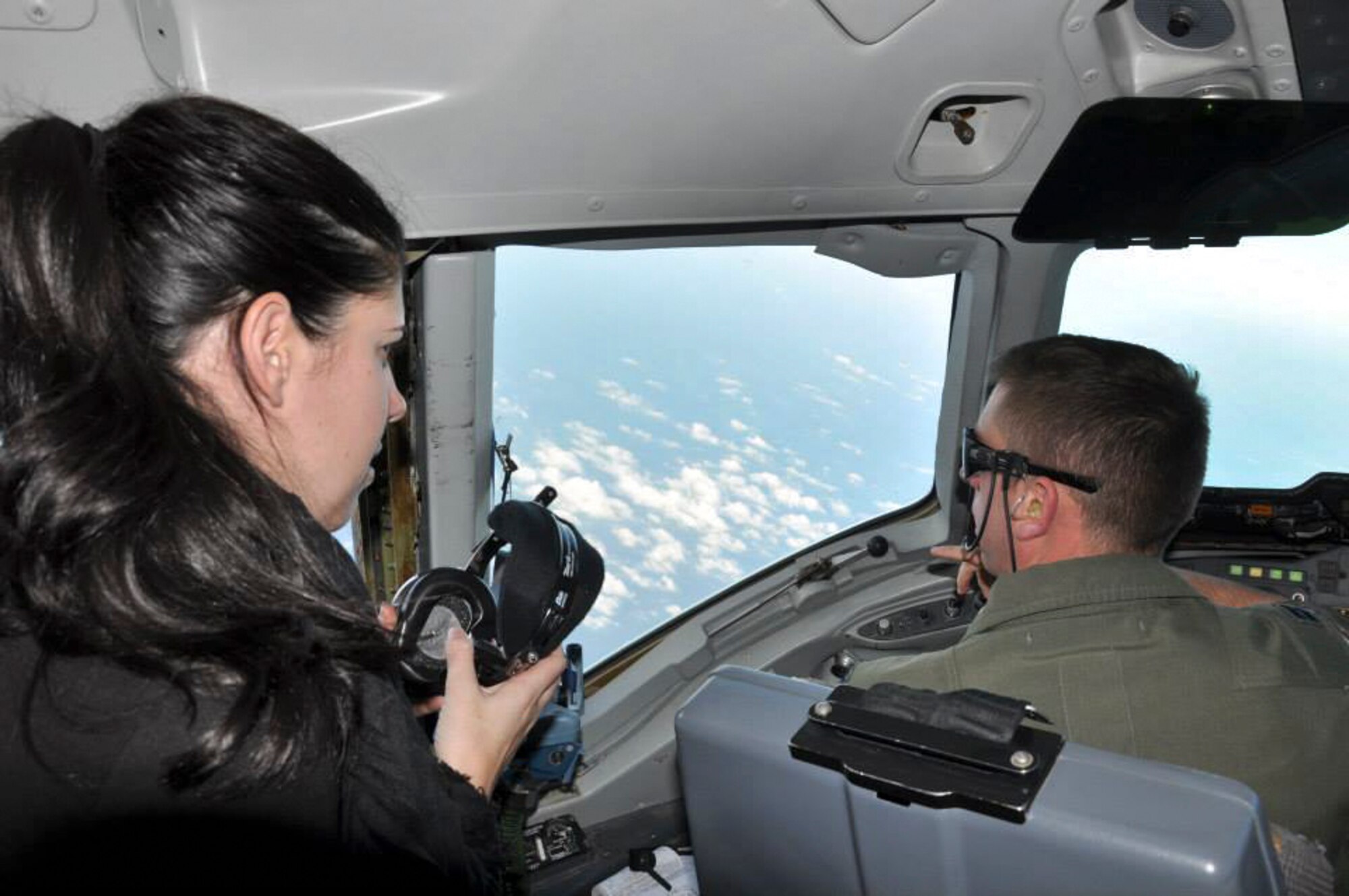 Capt. Matthew McCune, KC-10 Extender pilot, explains the capabilities of the KC-10 and F-15E Strike Eagle to a 48th Fighter Wing spouse during an aerial refueling mission over the North Sea Feb. 20, 2015. The flight gave spouses an opportunity to witness an aerial refueling mission firsthand and a better understanding of the jobs their loved ones perform on a regular basis.  (U.S. Air Force photo/Tech. Sgt. Jonathan E. White/Released)