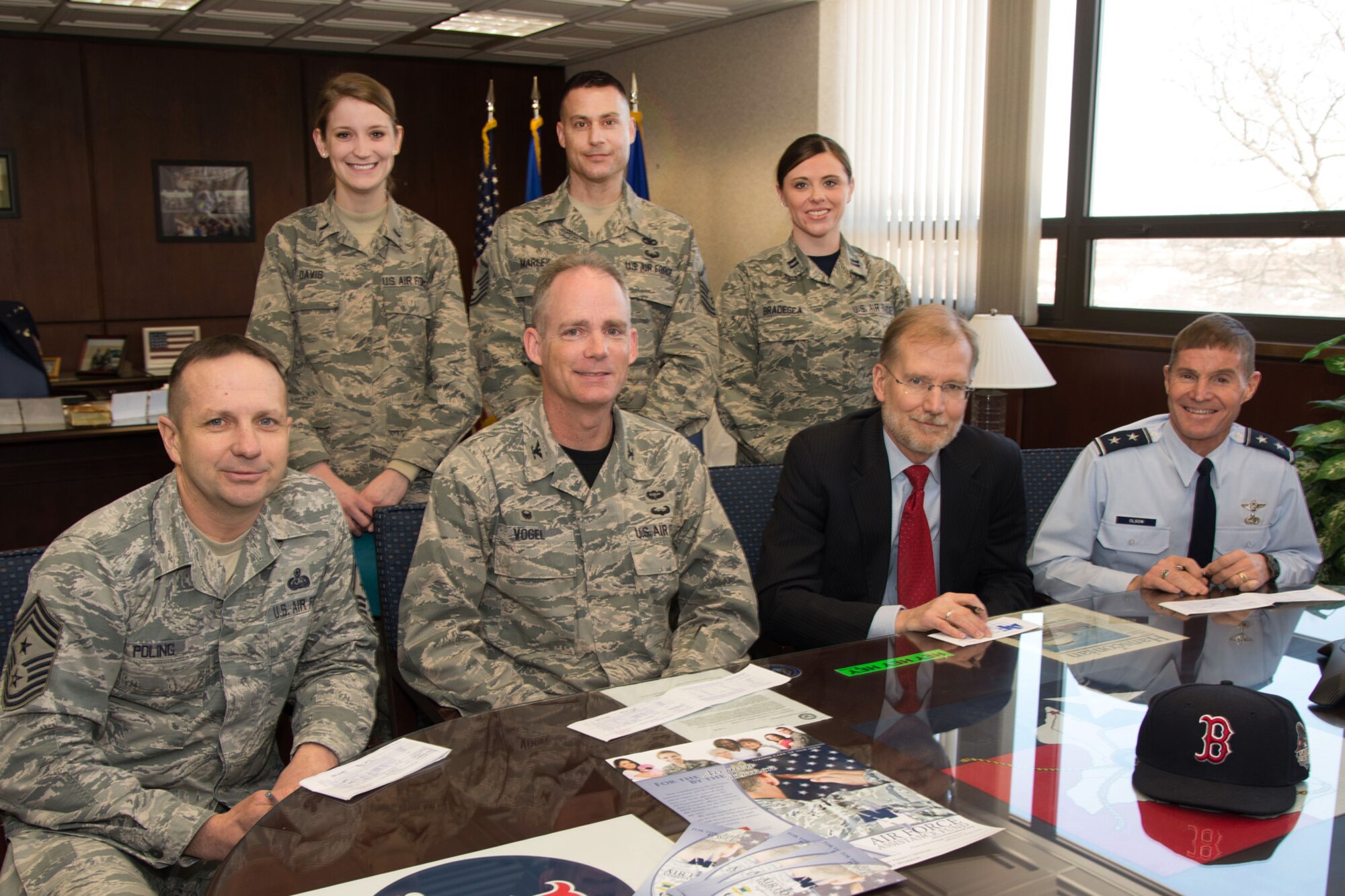 Maj. Gen. Craig S. Olson (sitting right to left), C3I and Networks Directorate program executive officer, and Steven D. Wert, Battle Management Directorate program executive officer, Col. Michael A. Vogel, 66th Air Base Group commander, and Hanscom Command Chief Master Sgt. Craig A. Poling pose alongside 1st Lt. Claire Davis, Master Sgt. Aaron Marley and Capt. Mandy Bradesca, Air Force Assistant Fund installation project officers, for a photograph prior to each completing an Air Force Assistance Fund contribution form in Building 1606, March 6. This year’s campaign will continue through May 1. (U.S. Air Force photo by Mark Herlihy)