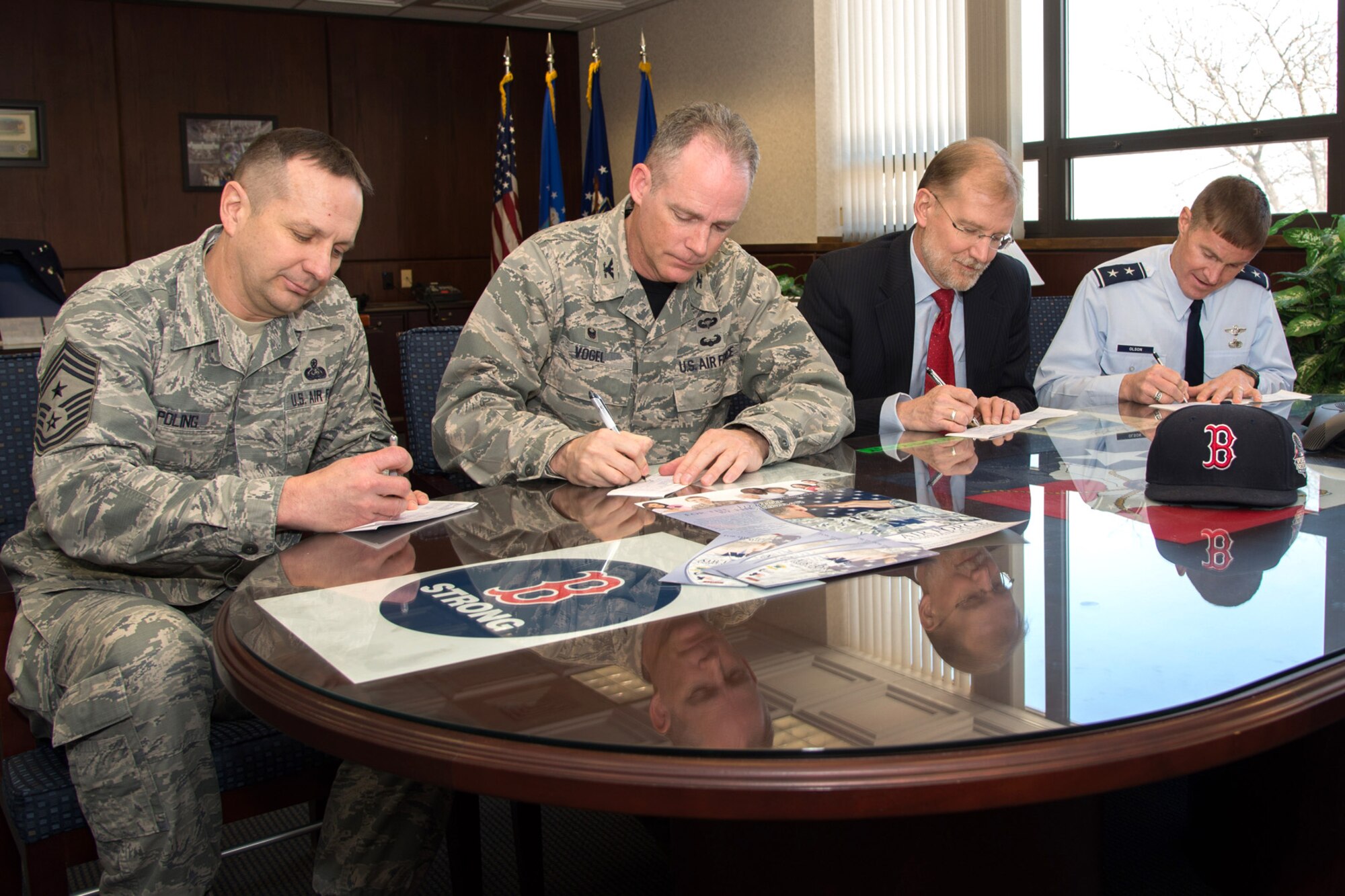 Hanscom senior leaders fill out their Air Force Assistance Fund contribution form in Building 1606, March 6. Seated are (right to left) Maj. Gen. Craig S. Olson, C3I and Networks Directorate program executive officer, and Steven D. Wert, Battle Management Directorate program executive officer, Col. Michael A. Vogel, 66th Air Base Group commander, and Hanscom Command Chief Master Sgt. Craig A. Poling. The 2015 Air Force Assistance Fund Campaign will get underway with a kick-off event at the Minuteman Commons March 20 at 3:30 p.m. This year’s campaign will continue through May 1. (U.S. Air Force photo by Mark Herlihy) 