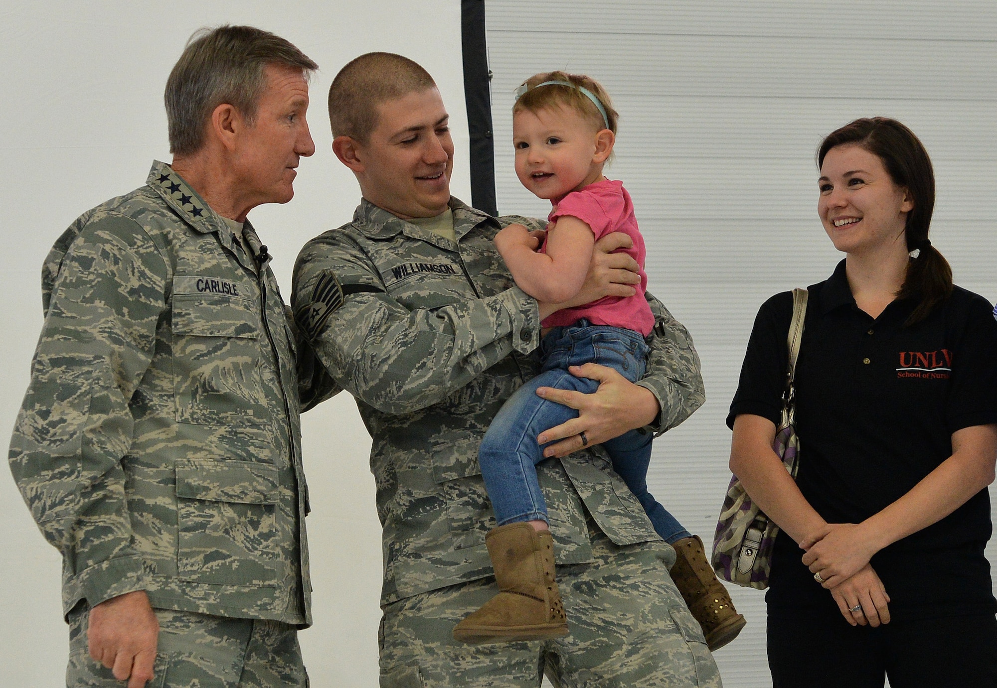 U.S. Air Force Gen. Hawk Carlisle, commander of Air Combat Command, talks to newly promoted Tech. Sgt. James Williamson, 432nd Wing, and his family during an all-call March 4, 2015, at Creech Air Force Base, Nevada. Carlisle promoted Williamson through the Stripes for Exceptional Performers (STEP) promotion system. (U.S. Air Force photo by Senior Airman Adarius Petty/Released)