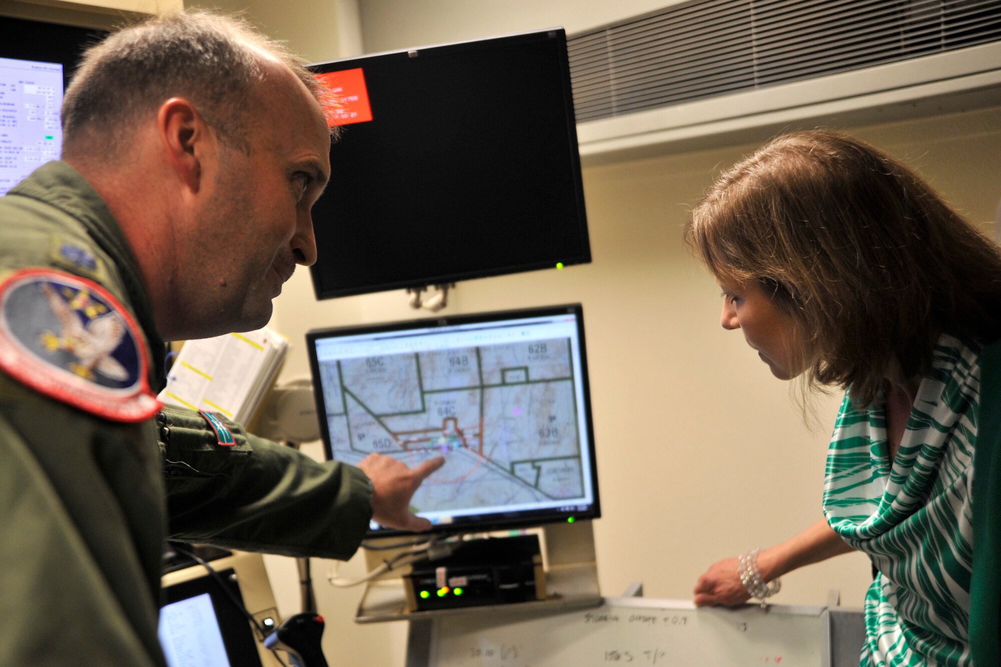 Mrs. Gillian Carlisle, wife of U.S. Air Force Gen. Hawk Carlisle, commander of Air Combat Command, receives a brief from Lt. Col. Leland Cowie, 11th Reconnaissance Squadron commander, on the purposes and capabilities of equipment within a ground control station used to remotely pilot the MQ-1 Predator and MQ-9 Reaper as part of a visit March 4, 2015, to Creech Air Force Base, Nevada. During her visit she toured the Airman & Family Readiness Center and the Airman Ministry Center to receive briefings on their functions, as well as, quality of life concerns on Creech AFB. (U.S. Air Force photo by Airman 1st Class Christian Clausen/Released)