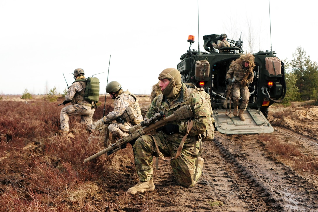 U.S. Army and Latvian snipers secure a perimeter during a combined live ...