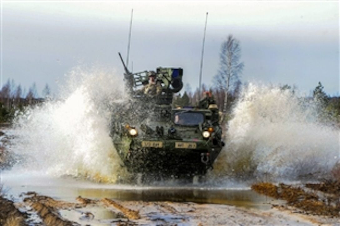 A U.S. Army Stryker armored vehicle splashes through a swampy area as it moves to an objective during a combined live-fire exercise with Latvian land forces as part of Operation Atlantic Resolve in the Adazi training area in Latvia, March 6, 2015. The soldiers are assigned to Mortar Platoon, Headquarters Troop, 2nd Cavalry Regiment.