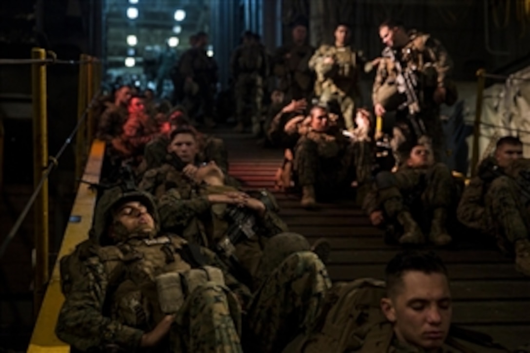 Marines sit staged to load into amphibious assault vehicles before a beach assault practice mission during amphibious squadron and Marine expeditionary unit integration training aboard the USS Rushmore off the coast of San Diego, March 5, 2015.