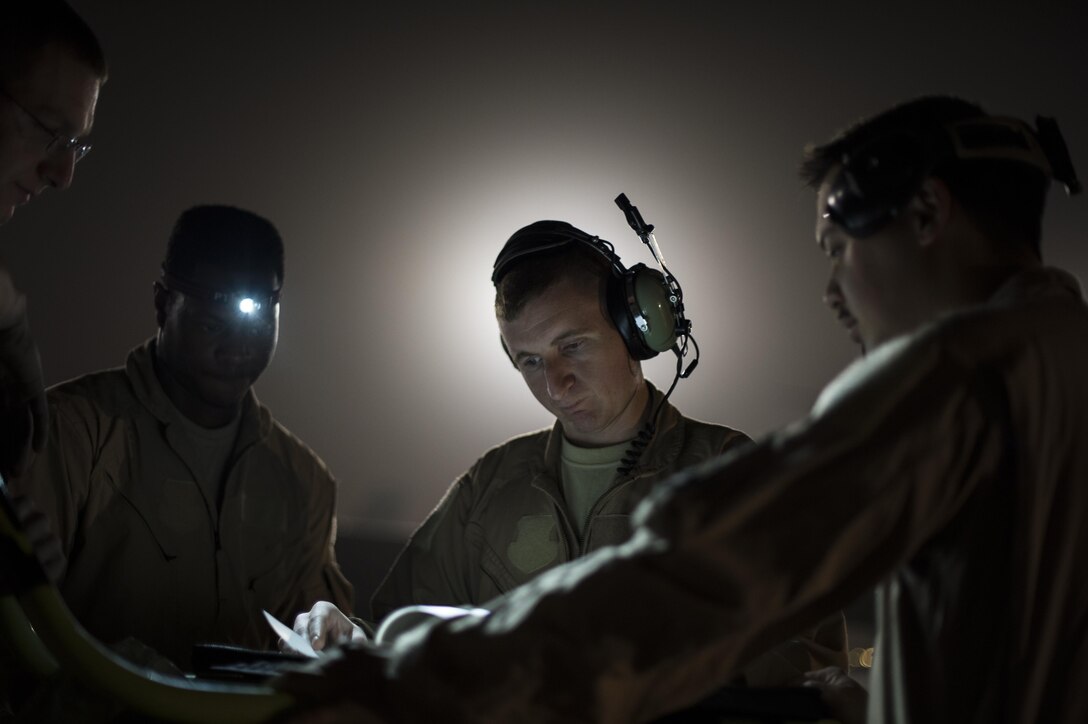 A U.S. Air Force KC-135 Stratotanker crew goes over paperwork with the crew chiefs before starting pre-flight checks, Mar 10, 2015 at Al Udeid Air Base, Qatar. The KC-135 will refuel Coalition F-15s and F-16s supporting Operation Inherent Resolve. (U.S. Air Force Photo by Staff Sgt. Perry Aston/not reviewed)