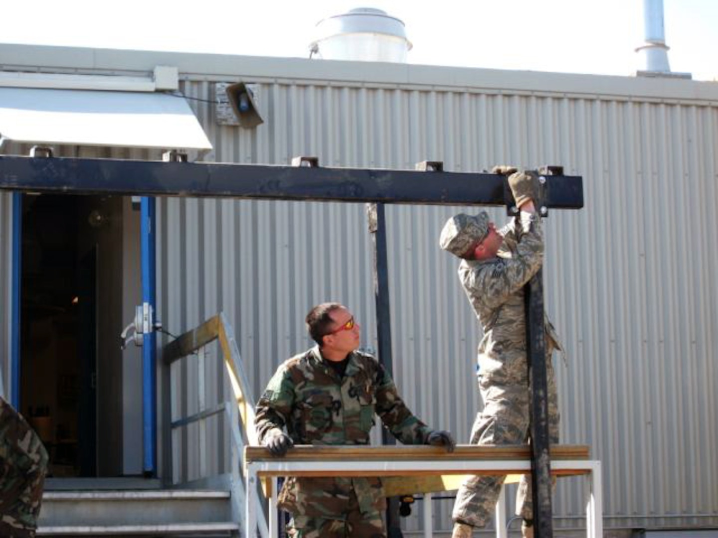 Guardsmen from the 139th Civil Engineering Squadron construct a canopy over a billeting facility at a Canadian Forward Operating Base (FOB) in support of the Engineering Exchange program in June