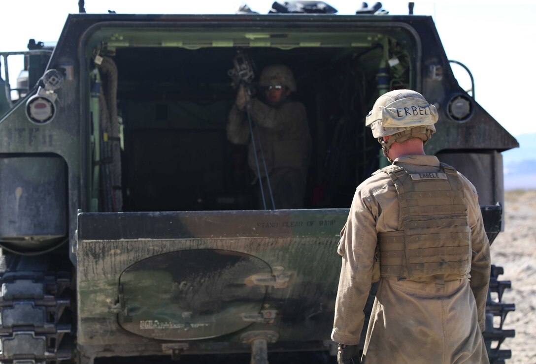Pfc. John Erbele, crew chief, watches as Sgt. Yesenia A. Nepita, rear crewman, AAV Plt., Co. B, GCEITF, conducts a manual raising of an AAV ramp using a ramp jack tool during the assessment at Range 500, Marine Corps Air Ground Combat Center Twentynine Palms, California, March 5, 2015. From October 2014 to July 2015, the GCEITF will conduct individual and collective level skills training in designated ground combat arms occupational specialties in order to facilitate the standards-based assessment of the physical performance of Marines in a simulated operating environment performing specific ground combat arms tasks. (U.S. Marine Corps photo by Cpl. Paul S. Martinez/Released)