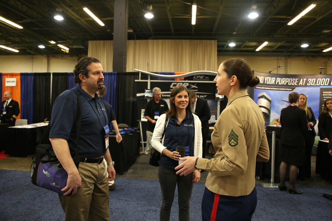 Marine Staff Sgt. Adele Grullon Knupp, an air support operations operator with Marine Air Support Squadron 1 in Cherry Point, N.C., explains the proper technique used to execute a flexed arm hang to an attendee of the Women in Aviation National Symposium Event in Dallas, Texas, March 6. Female Marine aviators attended this event to help young men and women get a better understanding of female aviation career opportunities in the Marine Corps.

