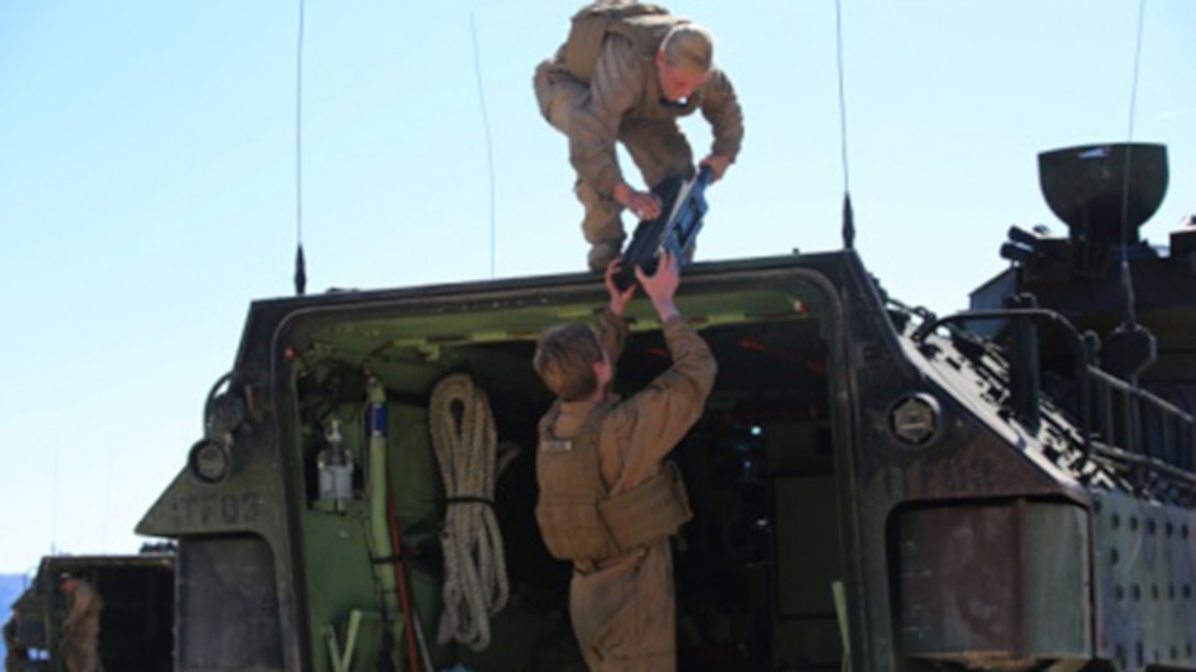 Sgt. Kassie McDole, top, crew chief, and Cpl. Kelsey Darling, rear crewman, both with Amphibious Assault Vehicle Platoon, Company B, Ground Combat Element Integrated Task Force, assist each other in weapons mounting during the assessment at Range 500, Marine Corps Air Ground Combat Center Twentynine Palms, California, March 5, 2015. From October 2014 to July 2015, the GCEITF will conduct individual and collective level skills training in designated ground combat arms occupational specialties in order to facilitate the standards-based assessment of the physical performance of Marines in a simulated operating environment performing specific ground combat arms tasks. 